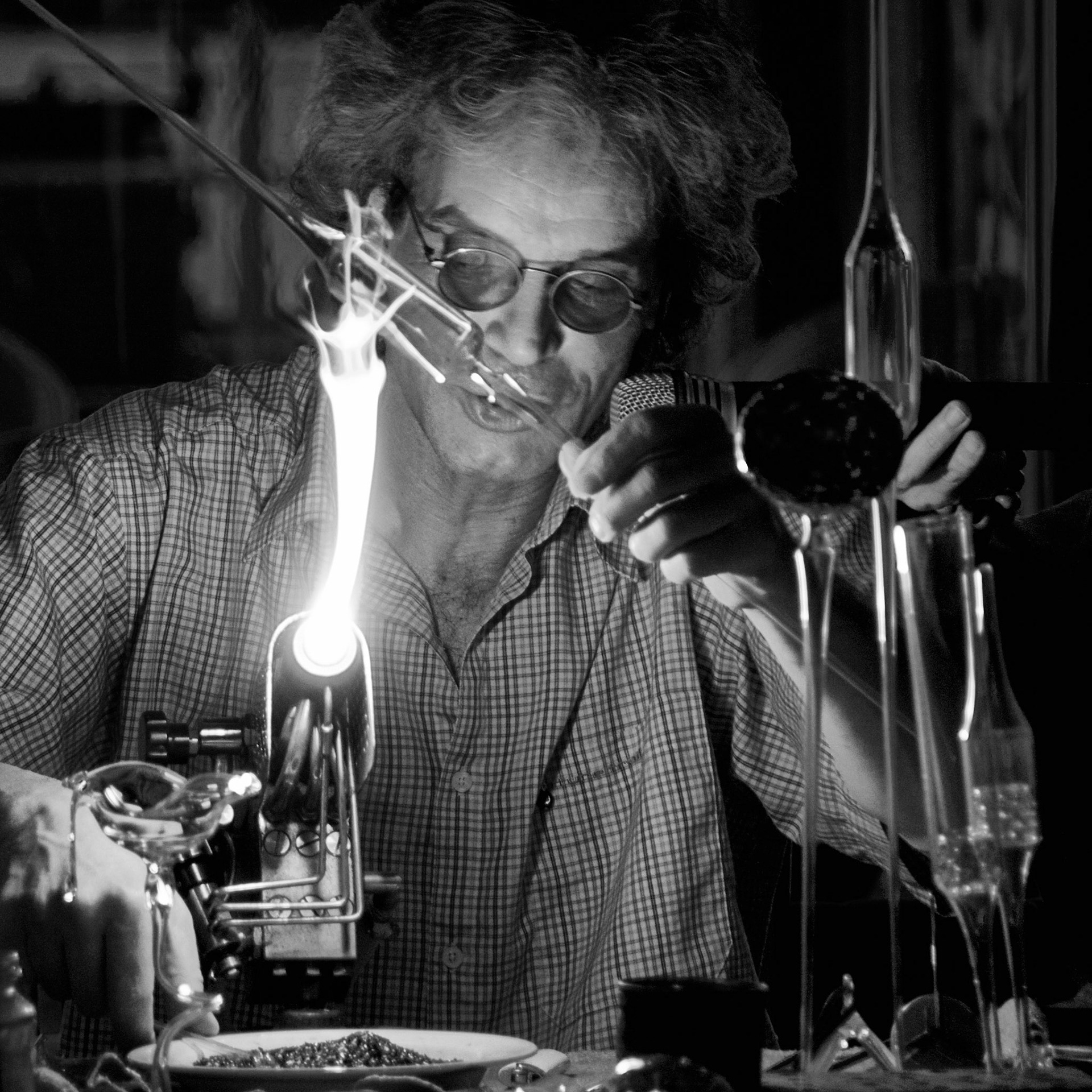 Glass Blower looks like mad scientist with bunsen burner