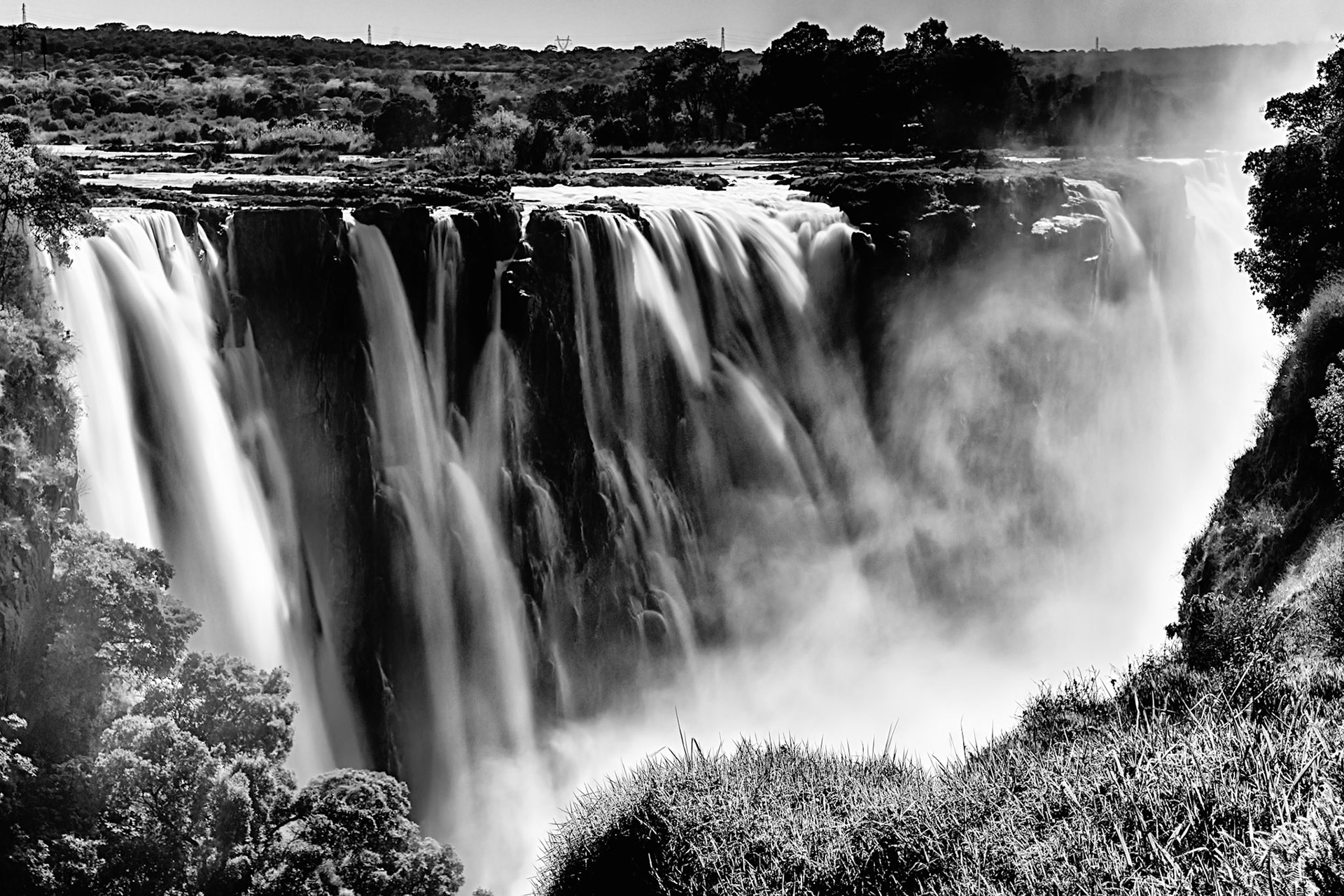 Mist rises like smoke as the thundering sound of Victoria Falls reverberates through the gorge.