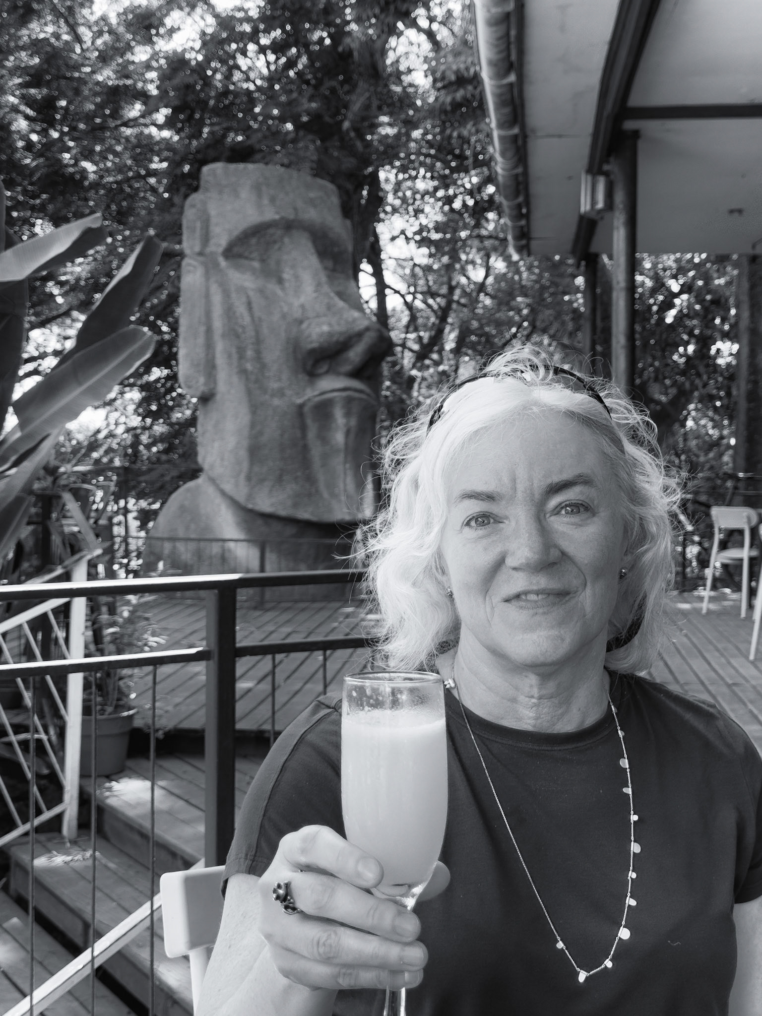 A very small replica Moai behind Paula as we enjoy a cocktail and late lunch while our room is made ready.