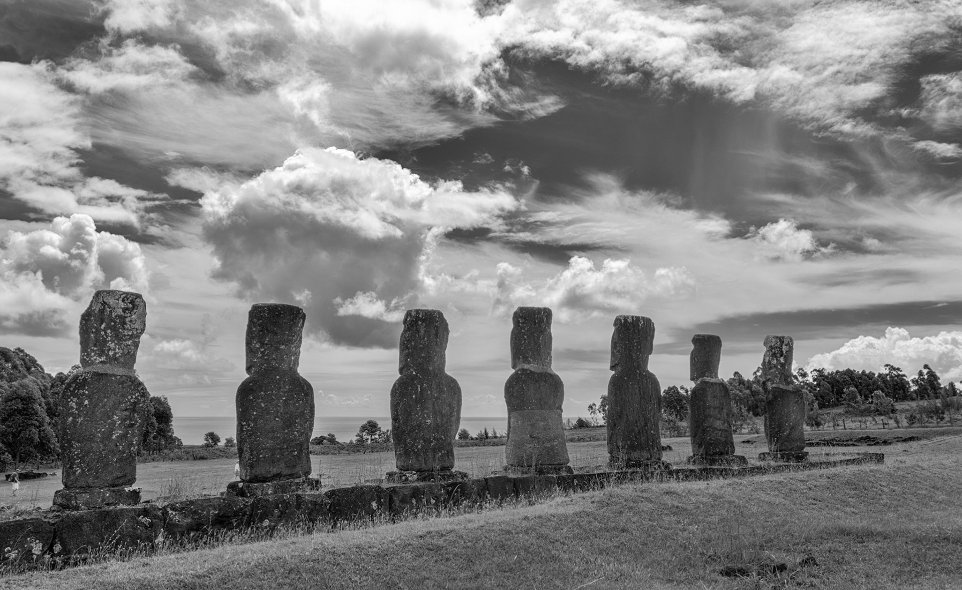 An example of an inland alter of 'smaller' Moai facing toward the ocean. Typically they face inland. Note it's impossible to know the state of the vegetation and view centuries ago.