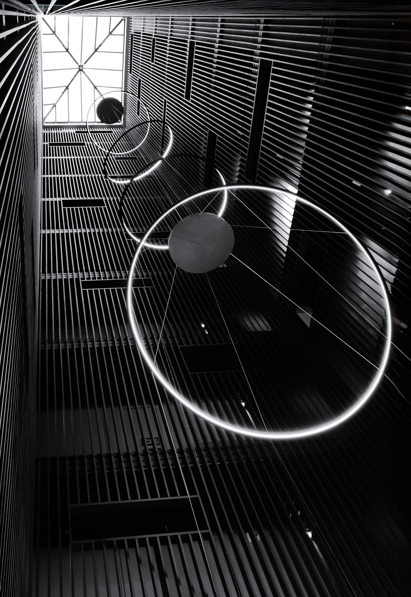 The contrast between the strong dark vertical corridor and the angled circular LED lights creates a lovel contrast of moving shapes, light, and dark which immediately caught my eye in the Olá Santiago Providencia hotel lobby.