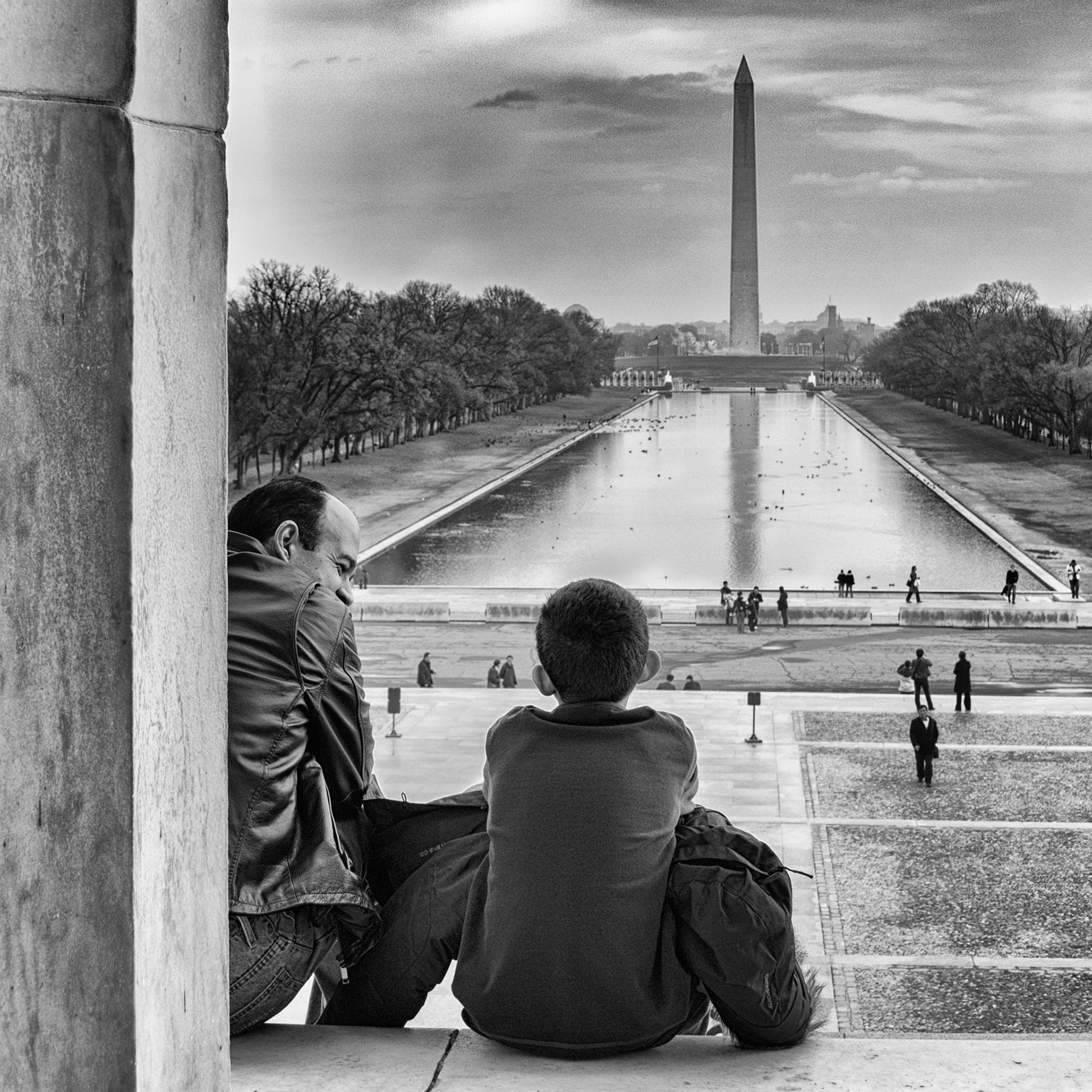 Taken from the Lincoln Memorial looking toward the Washington Monument on a foggy December day. I spotted this father and son enjoying a moment. I often wonder what dad appeared to be similing about (you can see a hint of a twinkle in his eye) and the son just feels to have a reflective tone about him.