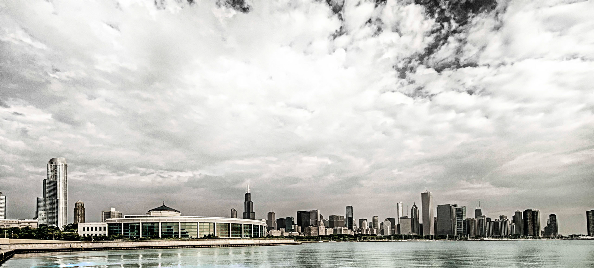 Vintage look at the Chicago skyline from the waterfront as seen from Adler Planetarium with Sneed Aquarium in the foreground