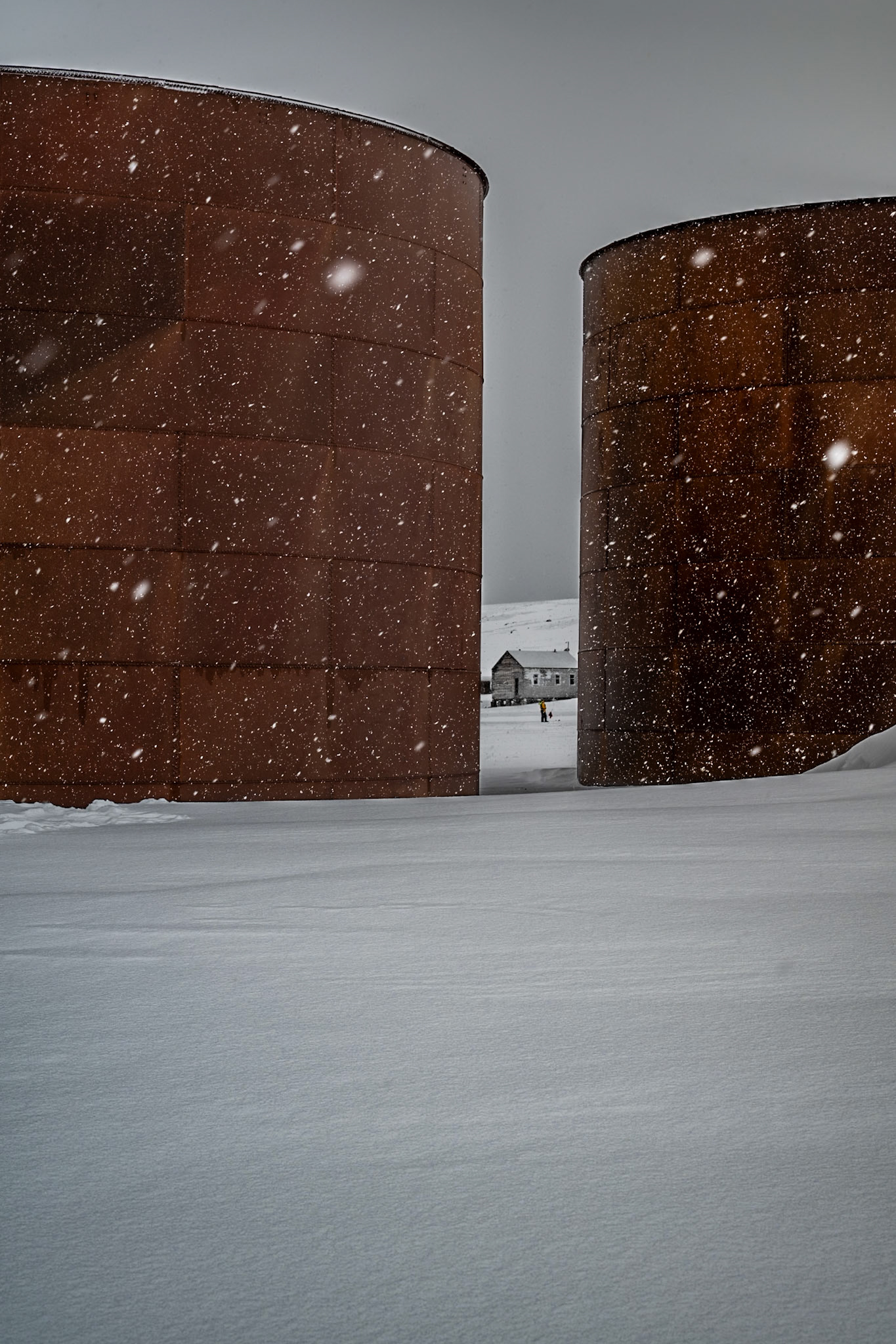 Long abandonded whale oil tanks on Deception Island. The distant person and building between the rusty red tanks caught my eye as it had wonderful contrast in the falling snow. In an abstract sense it reminded me of old rurar Alberta grain silos in the winter.
