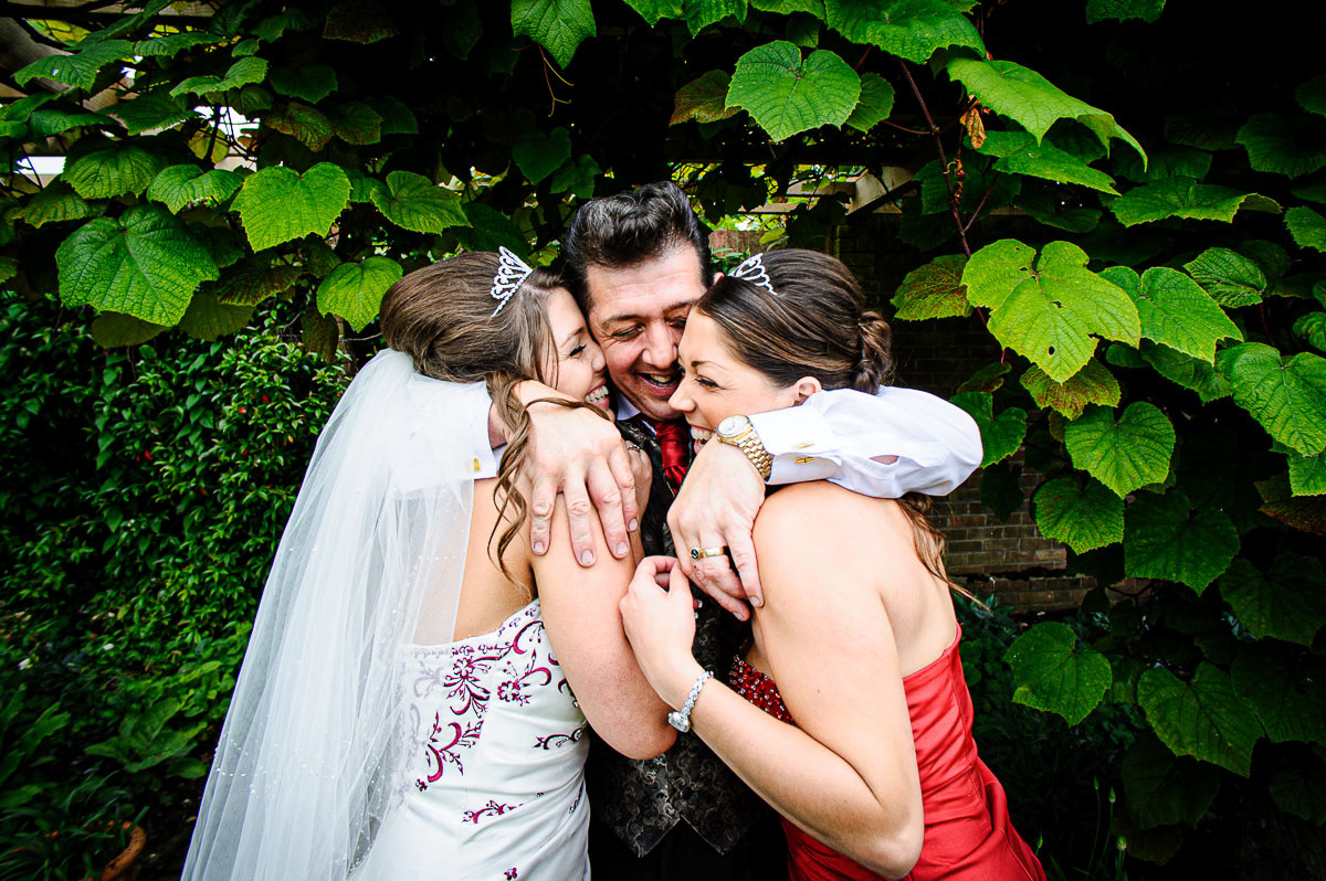 ather of the bride with his two daughters at an Elms Barn wedding in Suffolk.