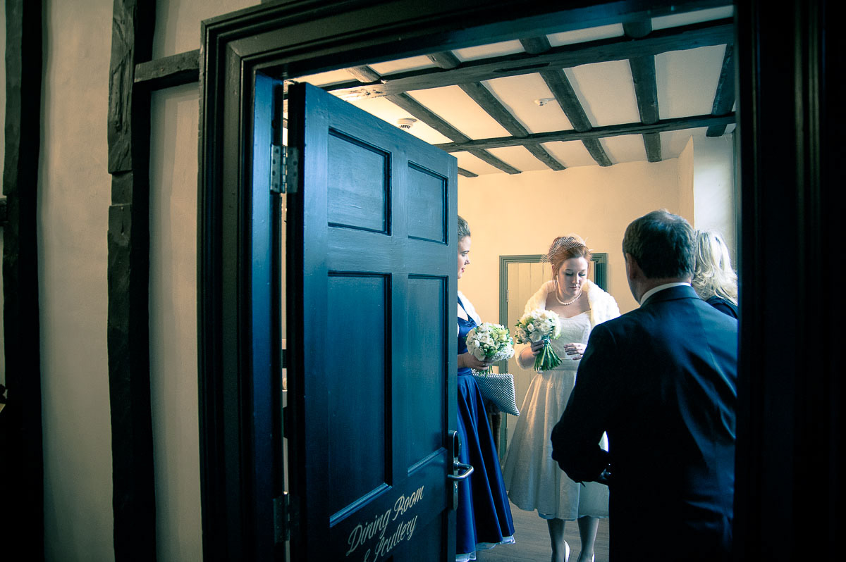 The bride waiting with her bridesmaid and father to make her entrance to her Ipswich wedding