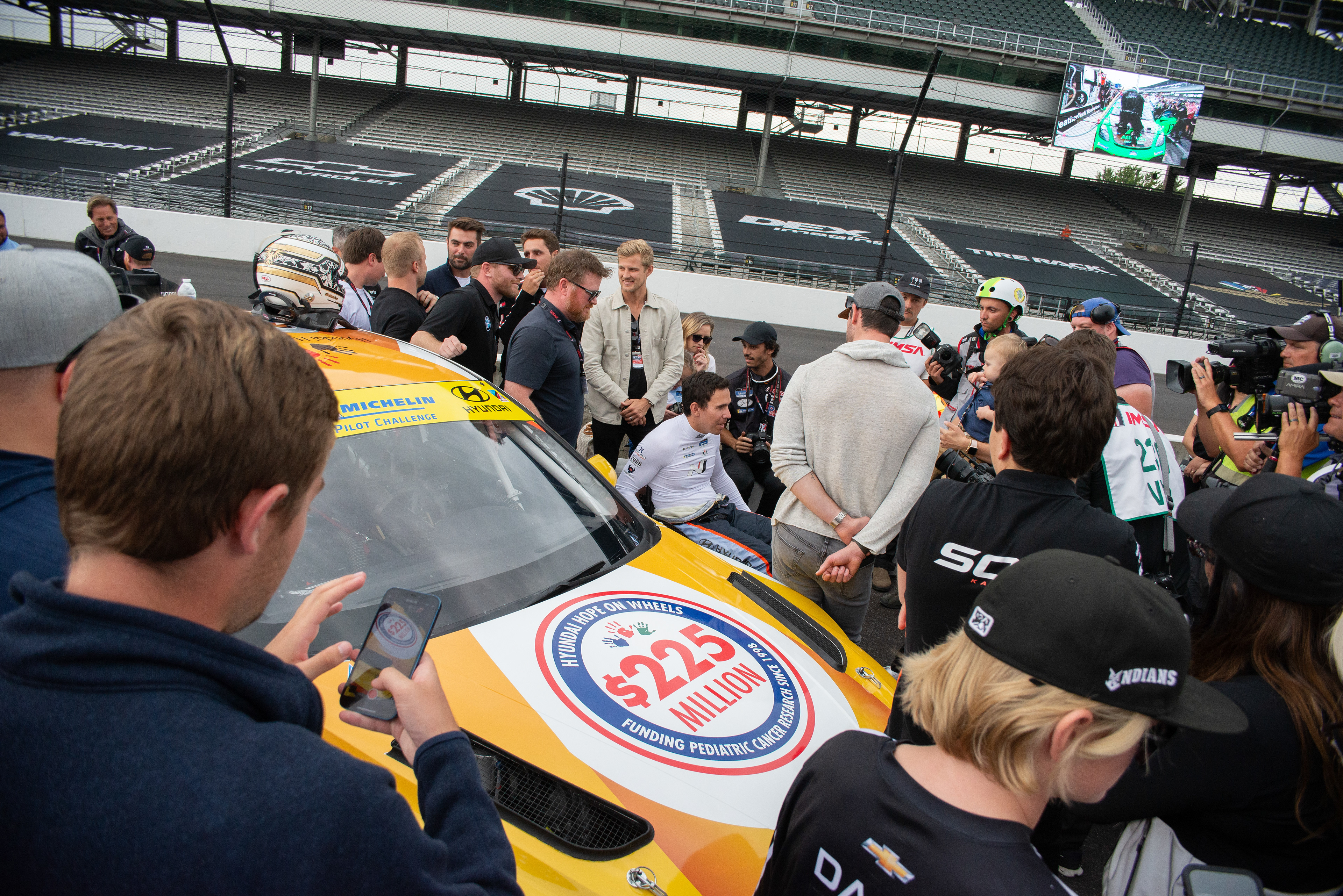 Driver Rober Wickens is the center of attention next to the number 33 Hyundai before the race.