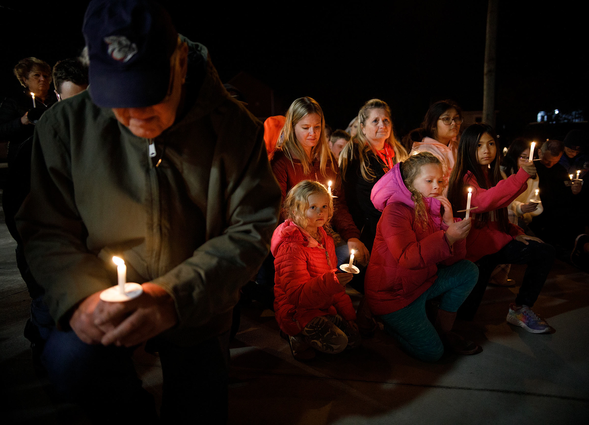 One year later, Liz Paris, daughters, Mia, 6, Lila, 9, and mother-in-law Carol hold candles during a candlelight vigil held Thursday, Dec. 7, 2023, for fallen firefighters Zachary Paris and Marvin Gruber outside New Tripoli Fire Station Thursday, Dec. 7, 2023, in Lynn Township.  Paris and Gruber died in the line of duty while fighting a house fire Dec. 7, 2022, in West Penn Township, Schuylkill County. (Jane Therese/Special to The Morning Call)
