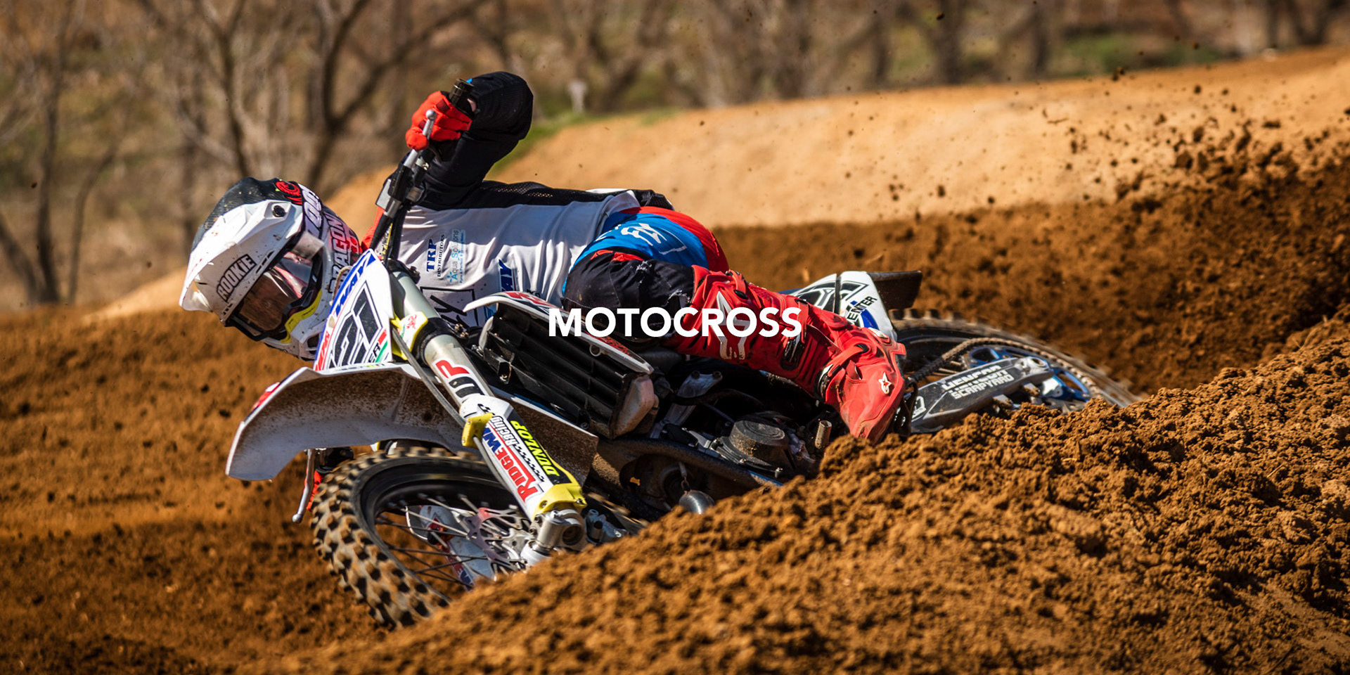 dynamic and energetic image of a motocross rider making a sharp turn on a race track with mud and dirt flying in the background,  a look of determination in his eyes photogrpahed by black rock studio