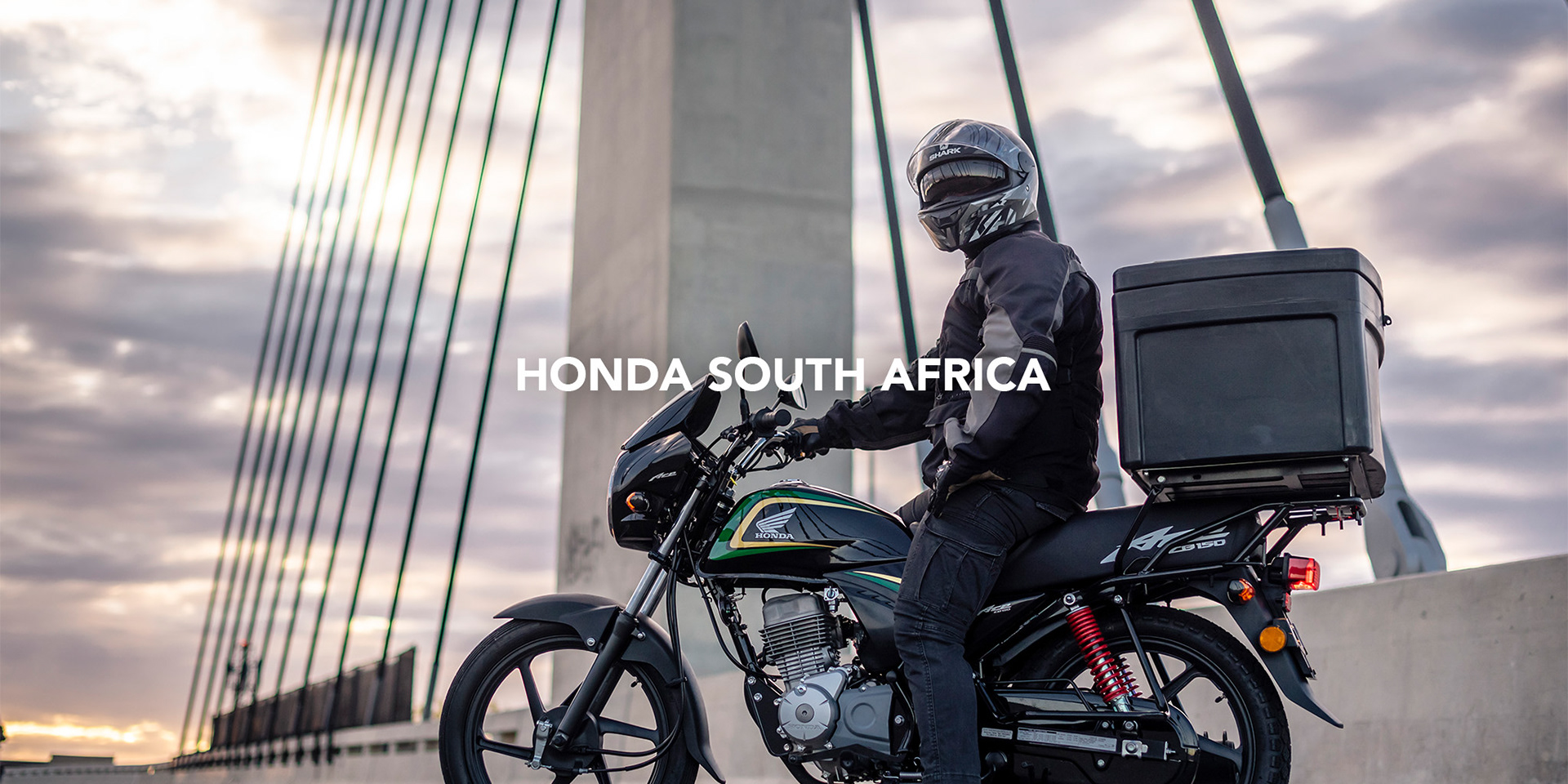 honda ace cb150 delivery motorcycle with a rider at sunset on sandton bridge in Sandton, johannesburg photographed by black rock studio for Honda Motors south africa for online advertising