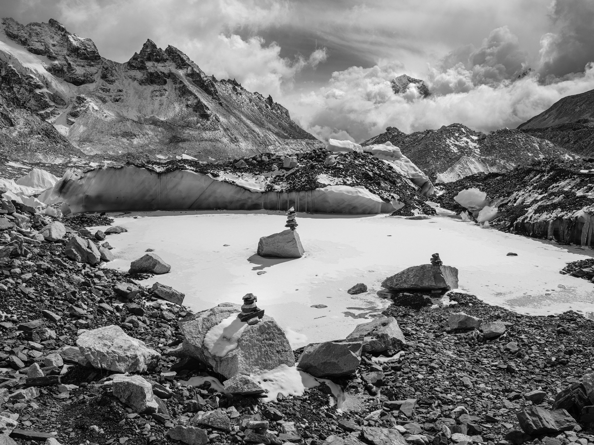 Man-made cairns at Everest base camp. The writing on the rock in the foreground reads: 'Happily ever after, love my kids'.