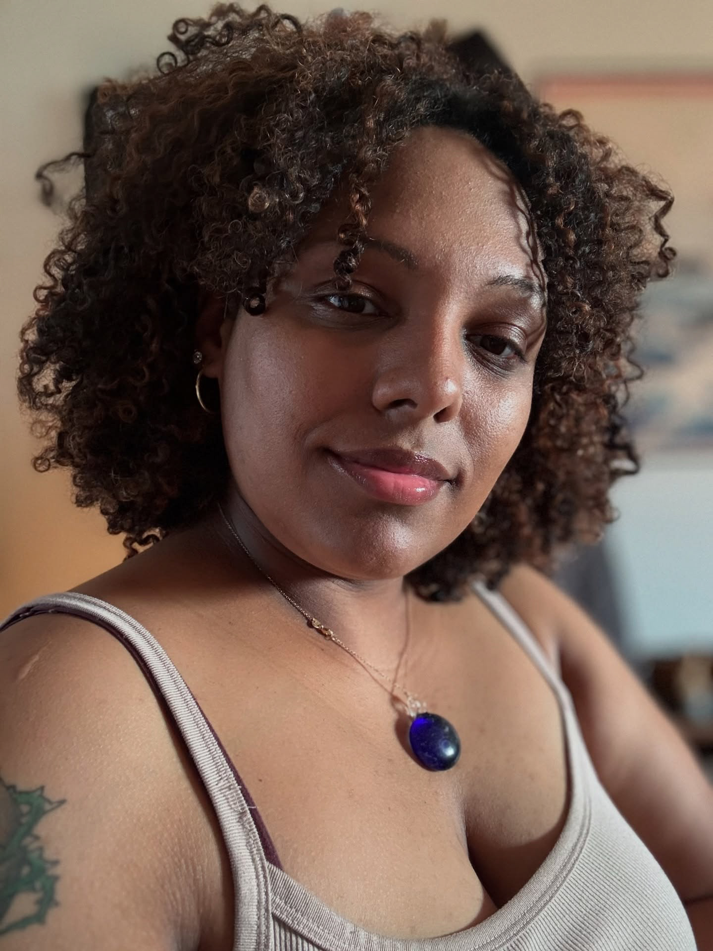 This is a selfie image of Sasha Cubero with a blog entry included with the image. She is wearing a blue necklace with curly hair.