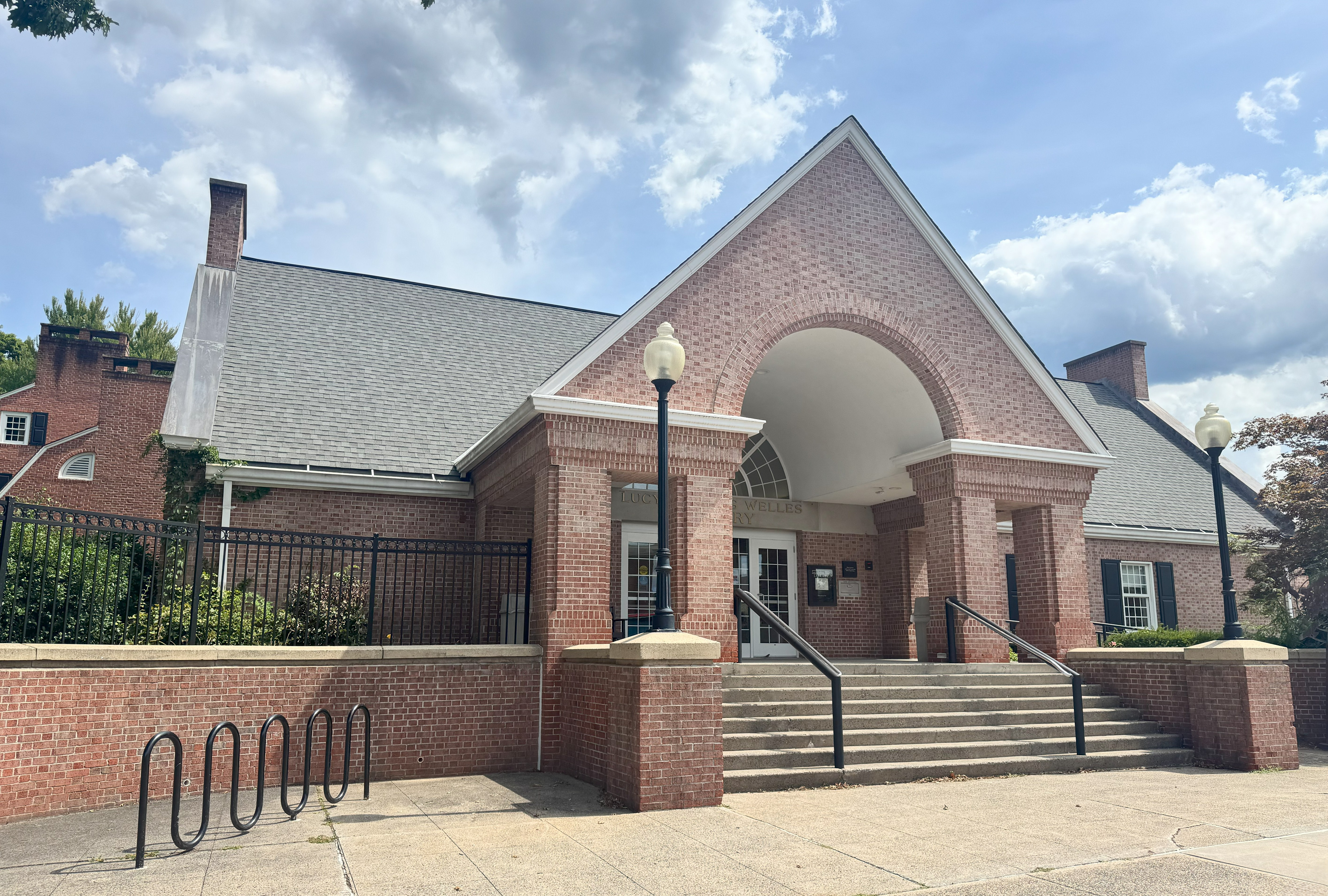 This shows the front view of a brick-building that is a library.