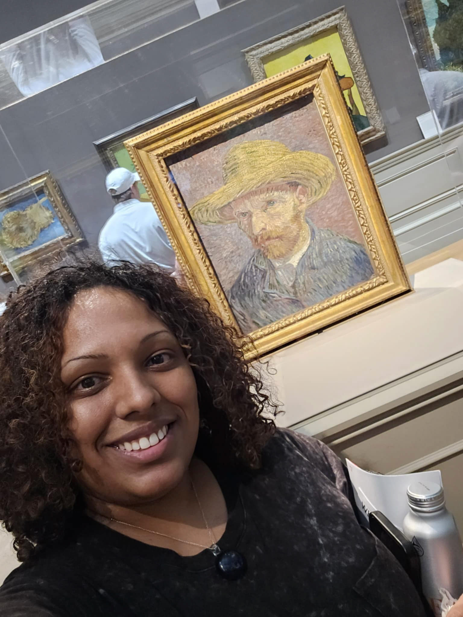 Sasha Cubero is posing in front of Vincent Van Gogh's portrait.