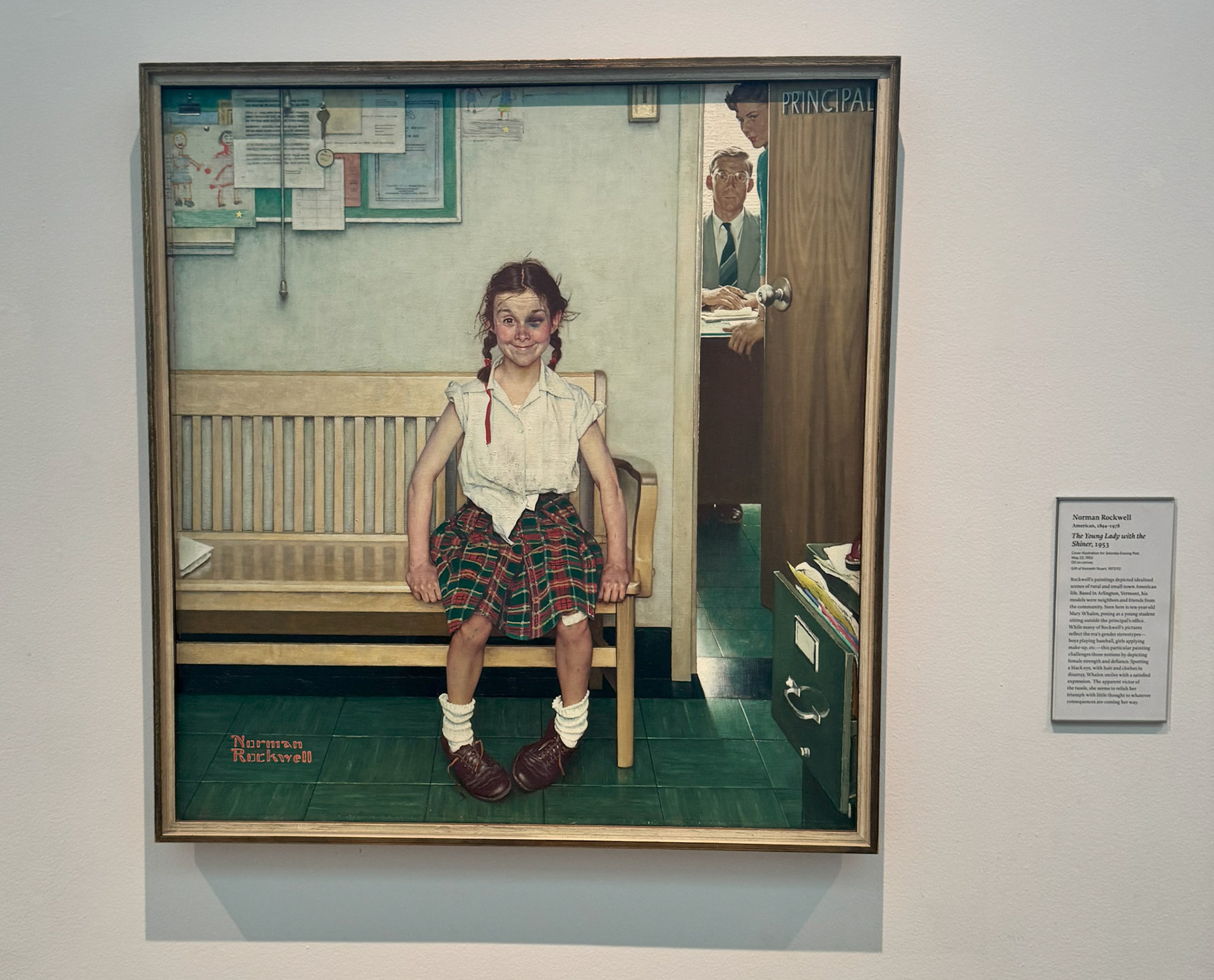 Shows a painting that depicts a young girl with a black eye and sitting by the principle's office.