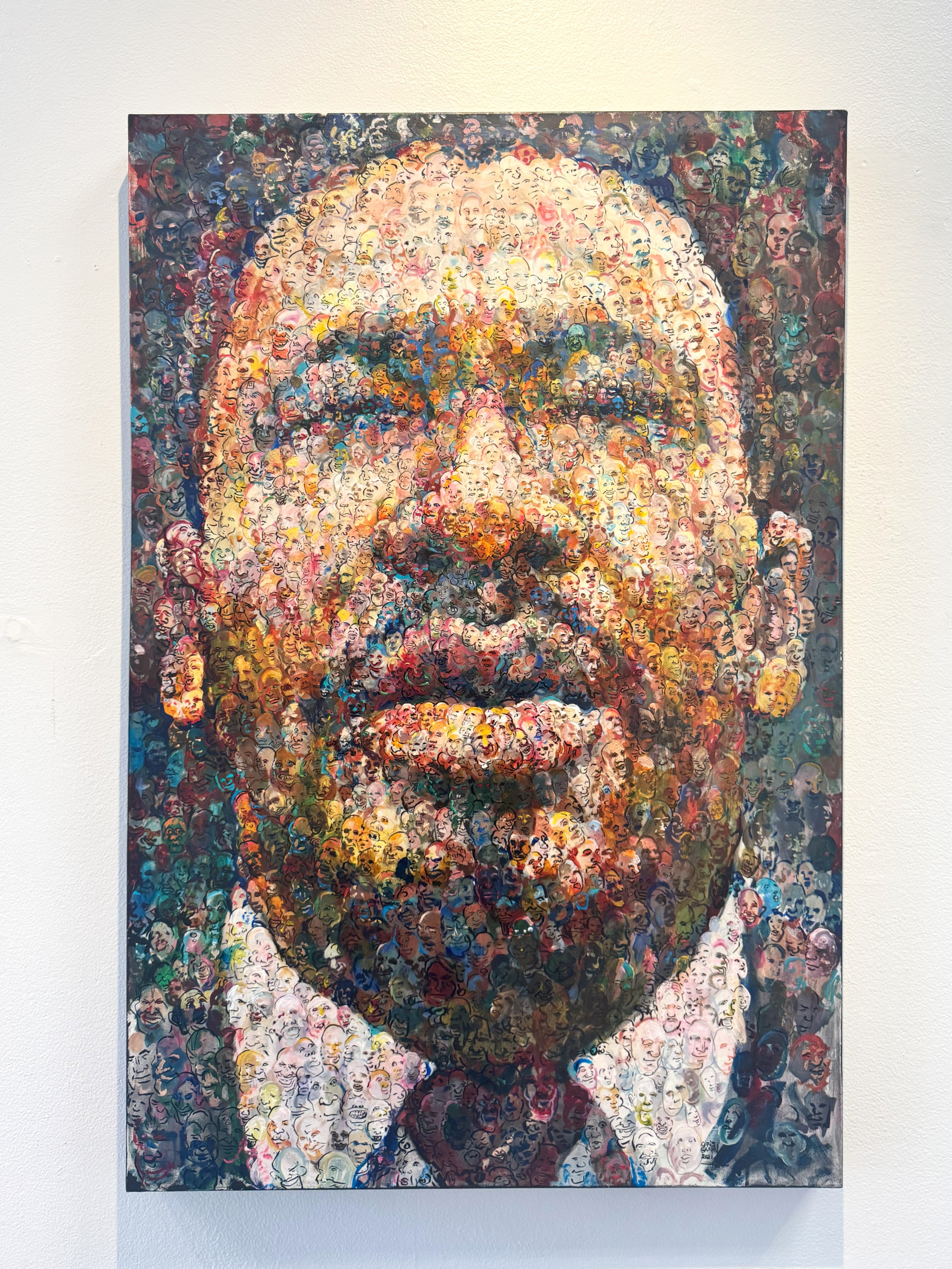 A painting of a man appears from a bunch of faces, created by Chris Gann.