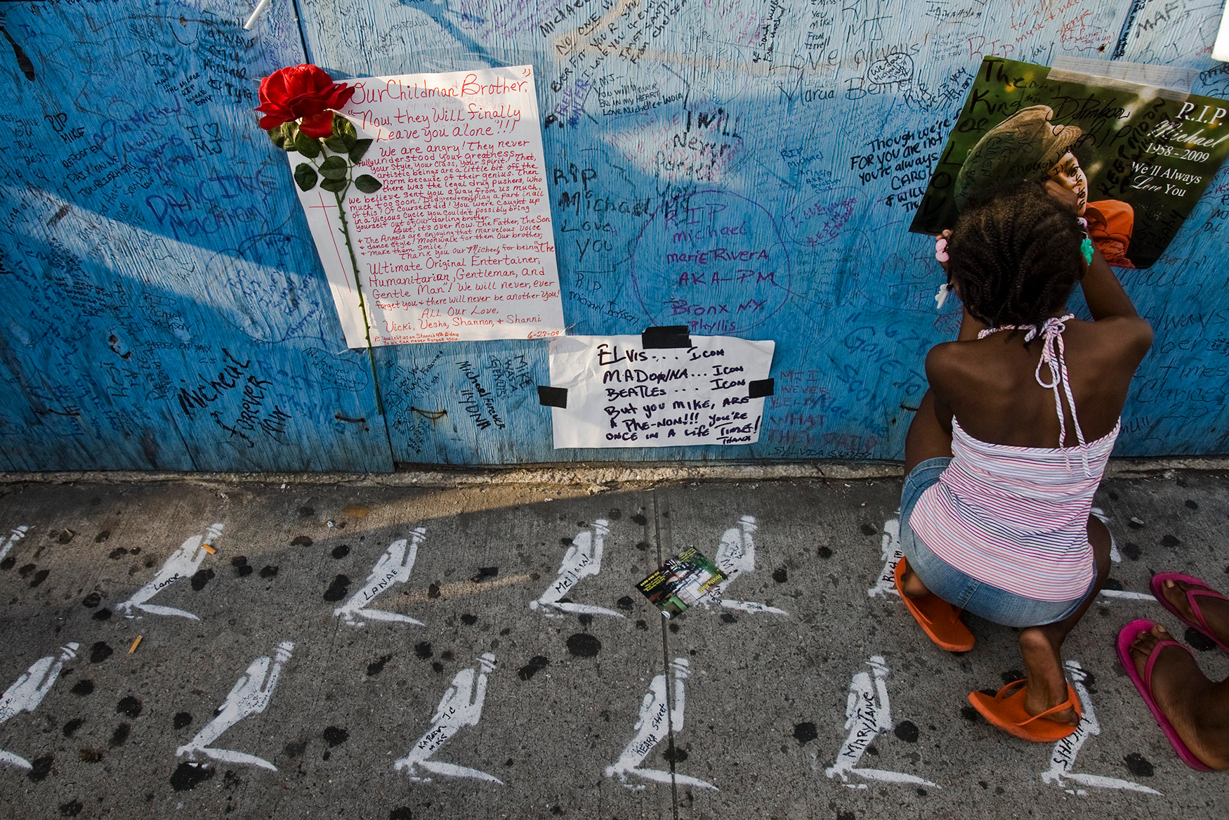 A fan of Michael Jackon, The King of Pop, signs the wall of Apollo Theatre at Harlem the day after his death, Harlem, Manhattan, 2009