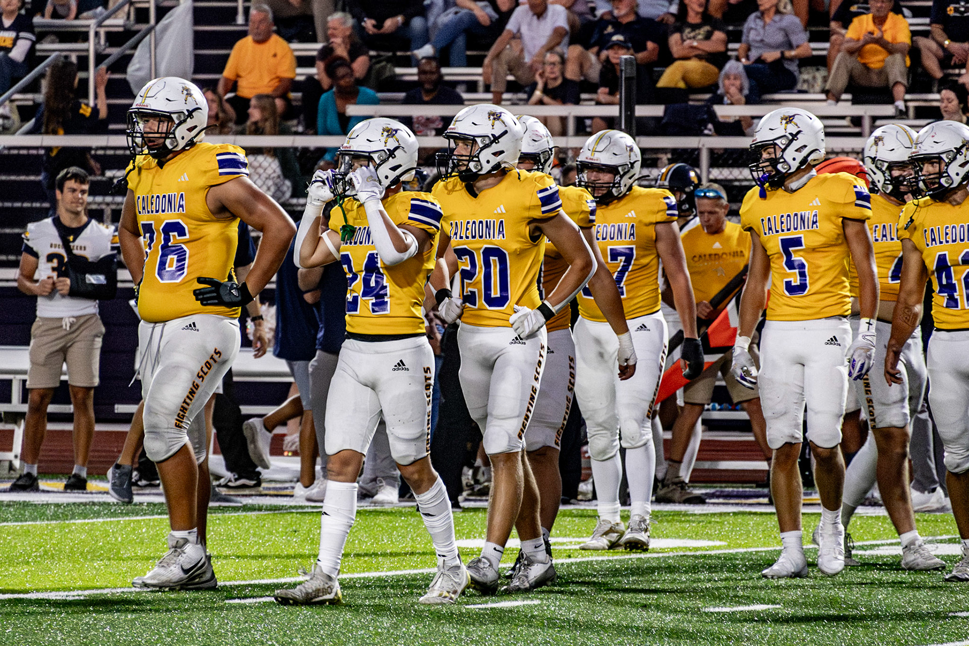 The Caledonia defense lines up on the ball, ready to stop the Grand Haven Buccaneers to secure the win. (Photo by Leo Xiong)