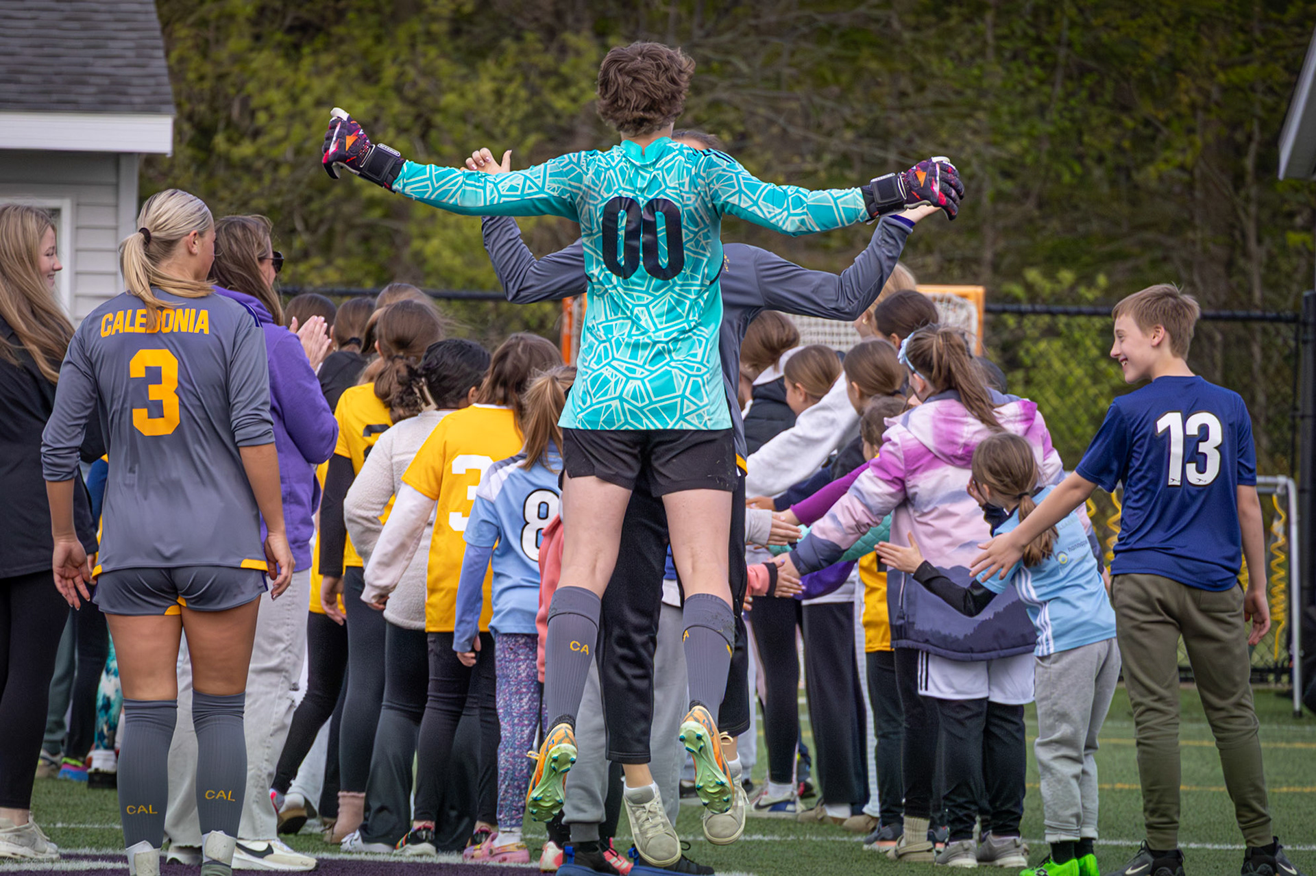 Lilli Ward celebrates with a chest bump after running through the kids’ tunnel during Youth Night. (Photo by Ava LaBine)