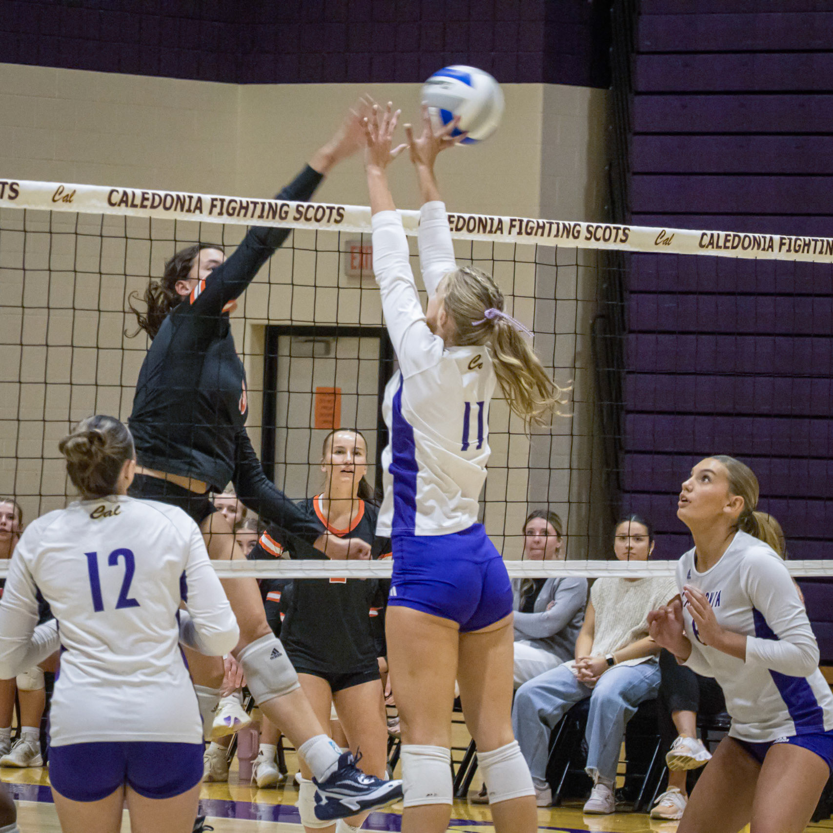 Senior Maggie Loomis gets up to block and tip's the hit from the Byron Center Bulldogs. (Photo By Kortney Muller)