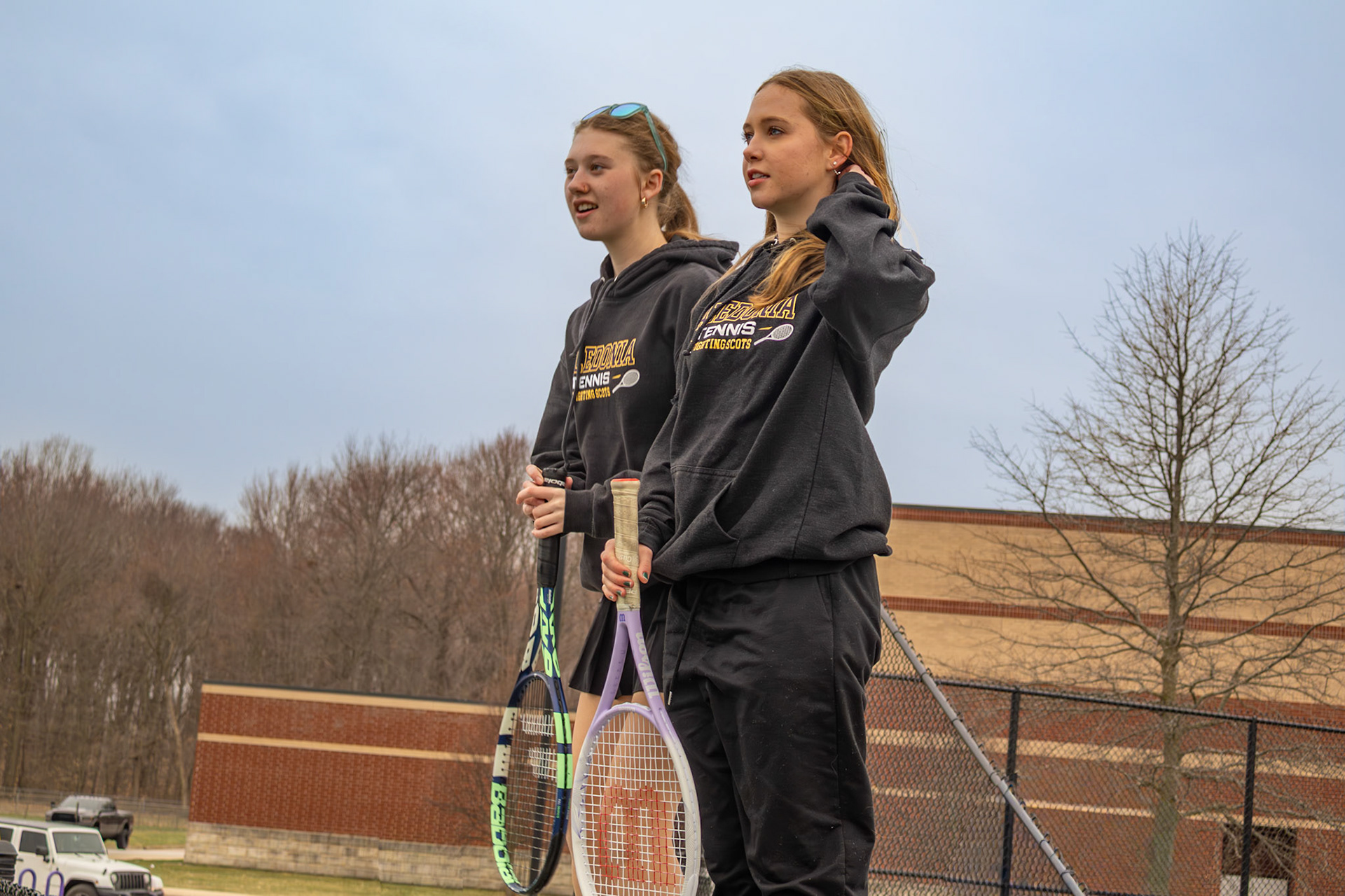 Ella Johnson and Eve Boersma support their team after warmups. (Photo by Ava LaBine)