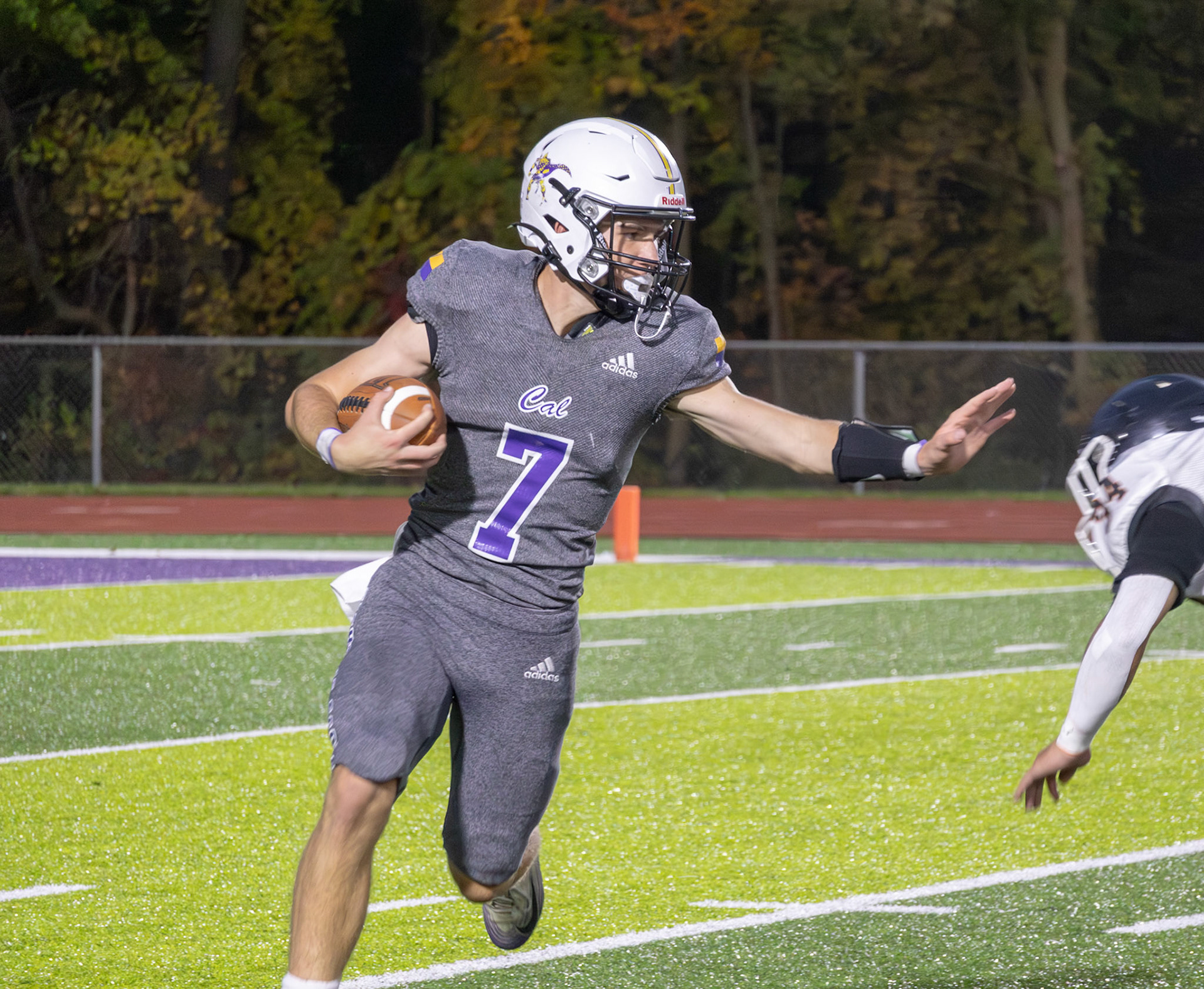 SCRAMBLE  JV Quarterback Oliver Olmstead charges down the field, scrambling through defenders keeping the play alive. (Photo by Khloe Lowande)