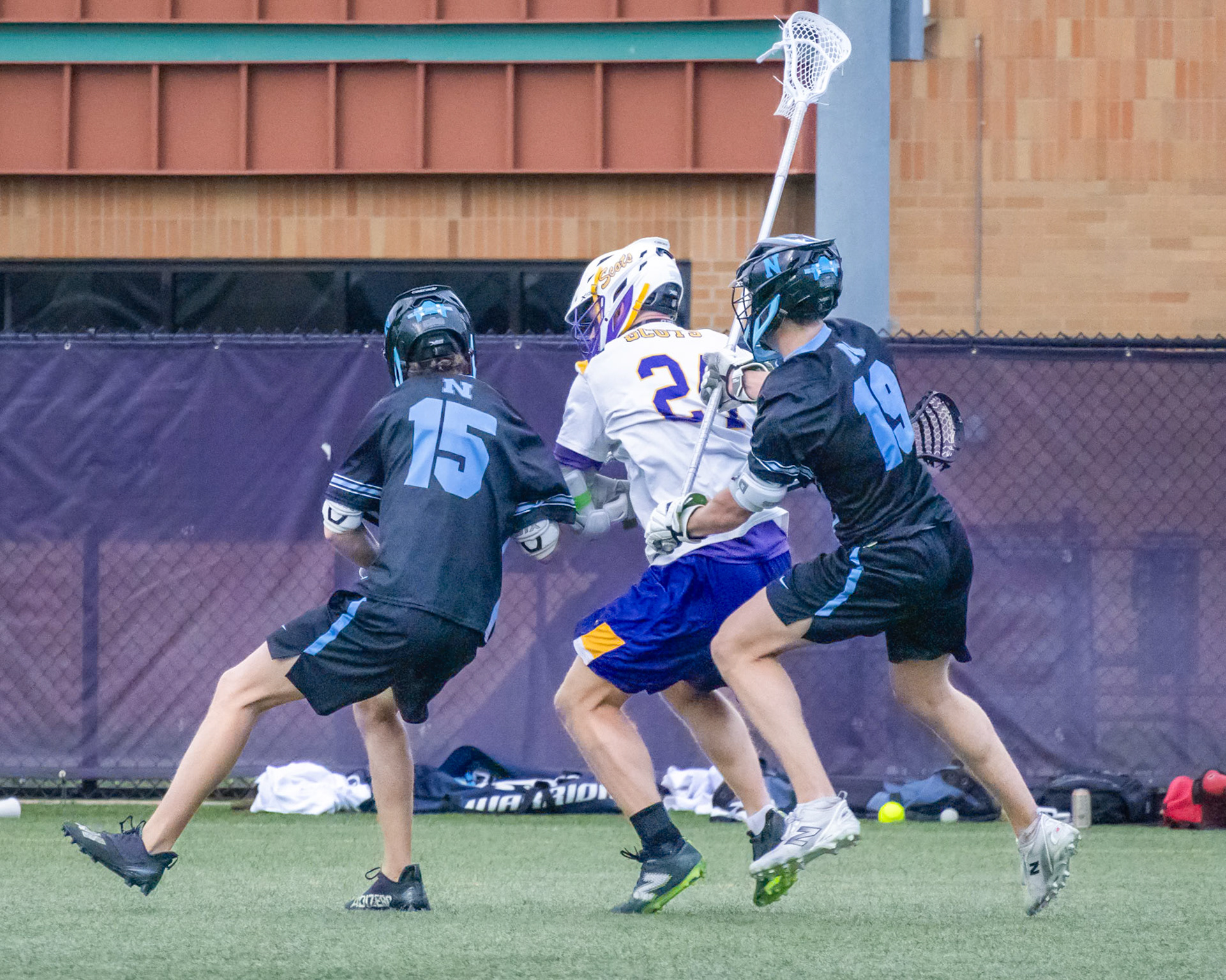 (44) Lincoln Senti gets sandwiched by two defenders but still drives toward the net for a scoring chance. (Photo by Ella-Grace Wickens)