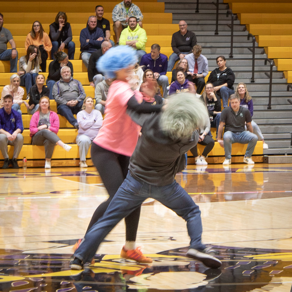 LAST WIG STANDIKNG During the Winterfest pep assembly, Maggie Loomis and her competitor battle it out to keep the last wig on until a winner is crowned. (Photo by Abby Skibinski)