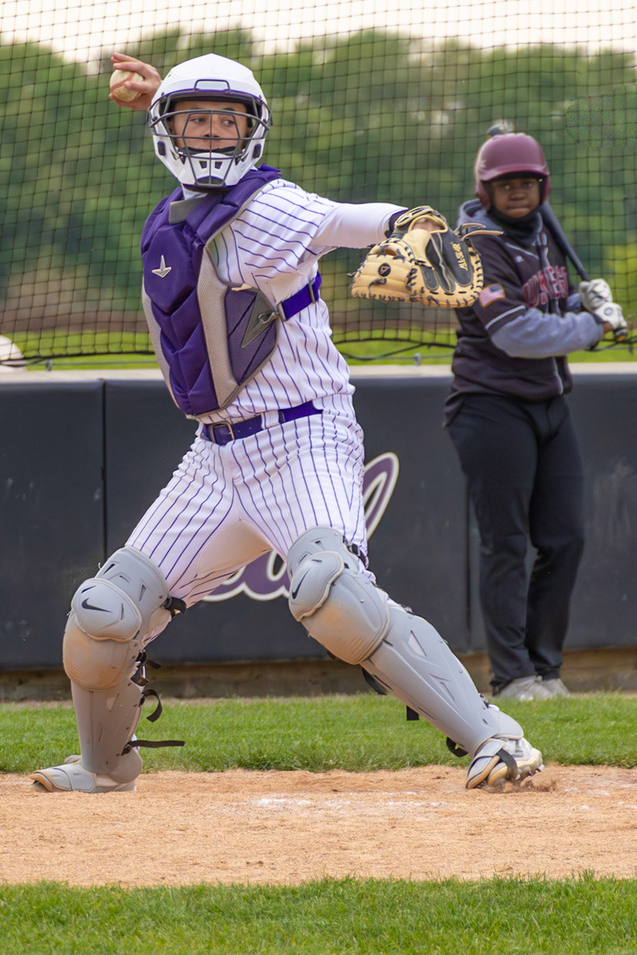 Jackson McNew pops up from behind the plate and fires a throw during the Scots’ matchup against Muskegon. (Photo by Vivian Hoffman)