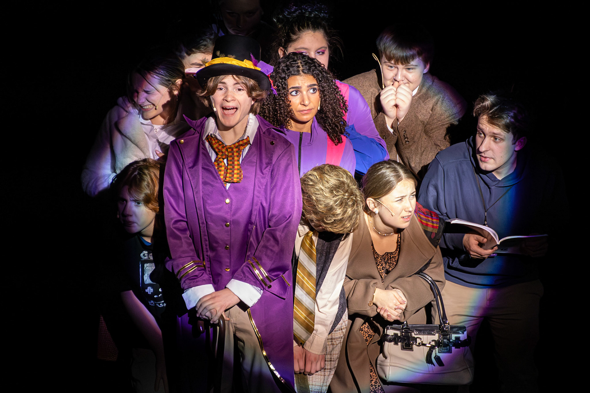 Packed tightly together, the children are squeezed into the factory entrance as Willy Wonka, played by senior Cody Winters, leads them in song, setting the tone for the adventure ahead. (Photo by Mackenzie Popma)