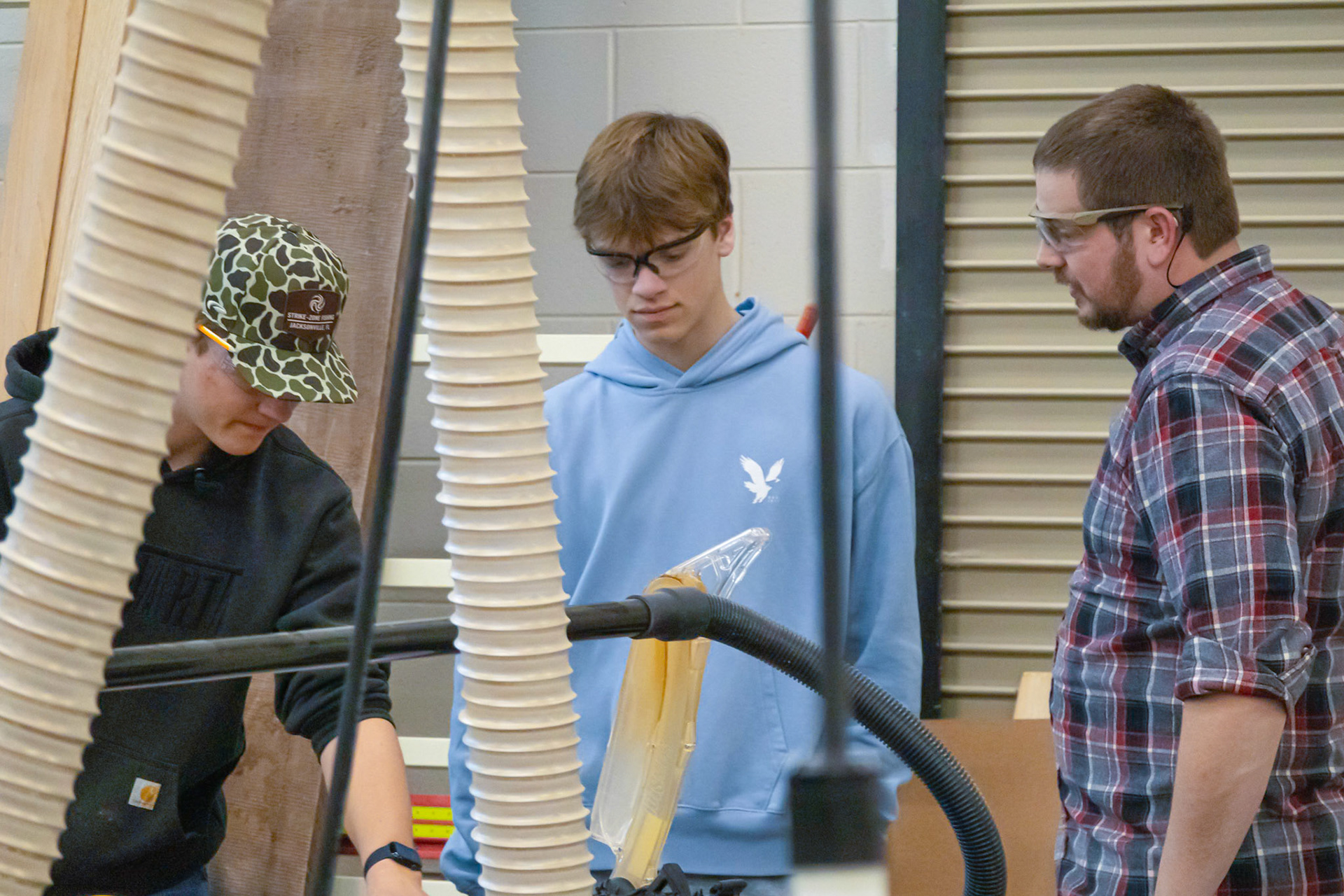 SKILL BUILDING - Senior Kaden Van Ryn pauses mid-project in Advanced Woodworking, asking Mr. Scholten for a little guidance. (Photo by Natalia Teneyuque)