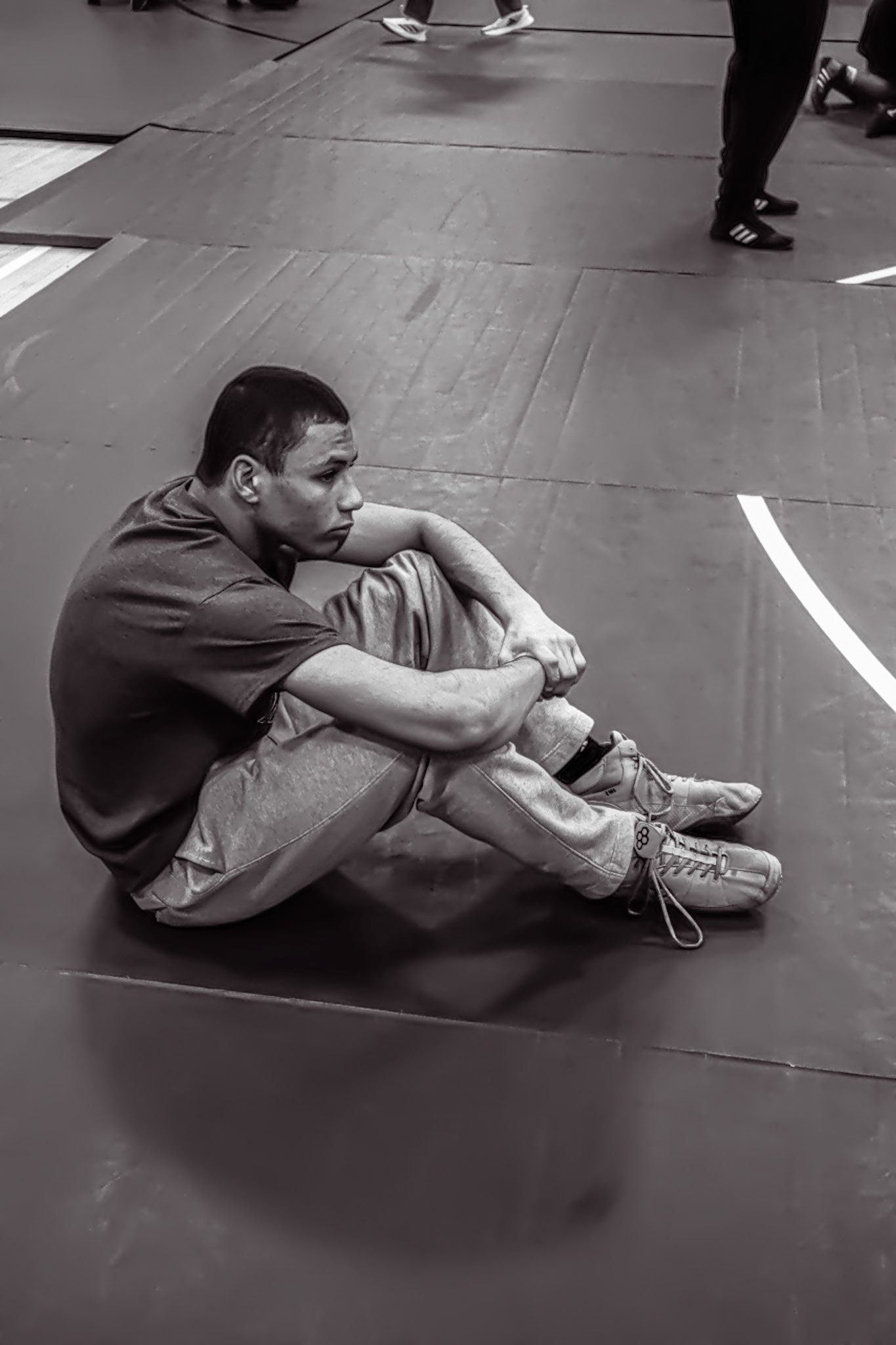 Robert Restau, still fighting his way to states, takes a break and watches the younger wrestlers compete. (Photo by Joseph Dunn)