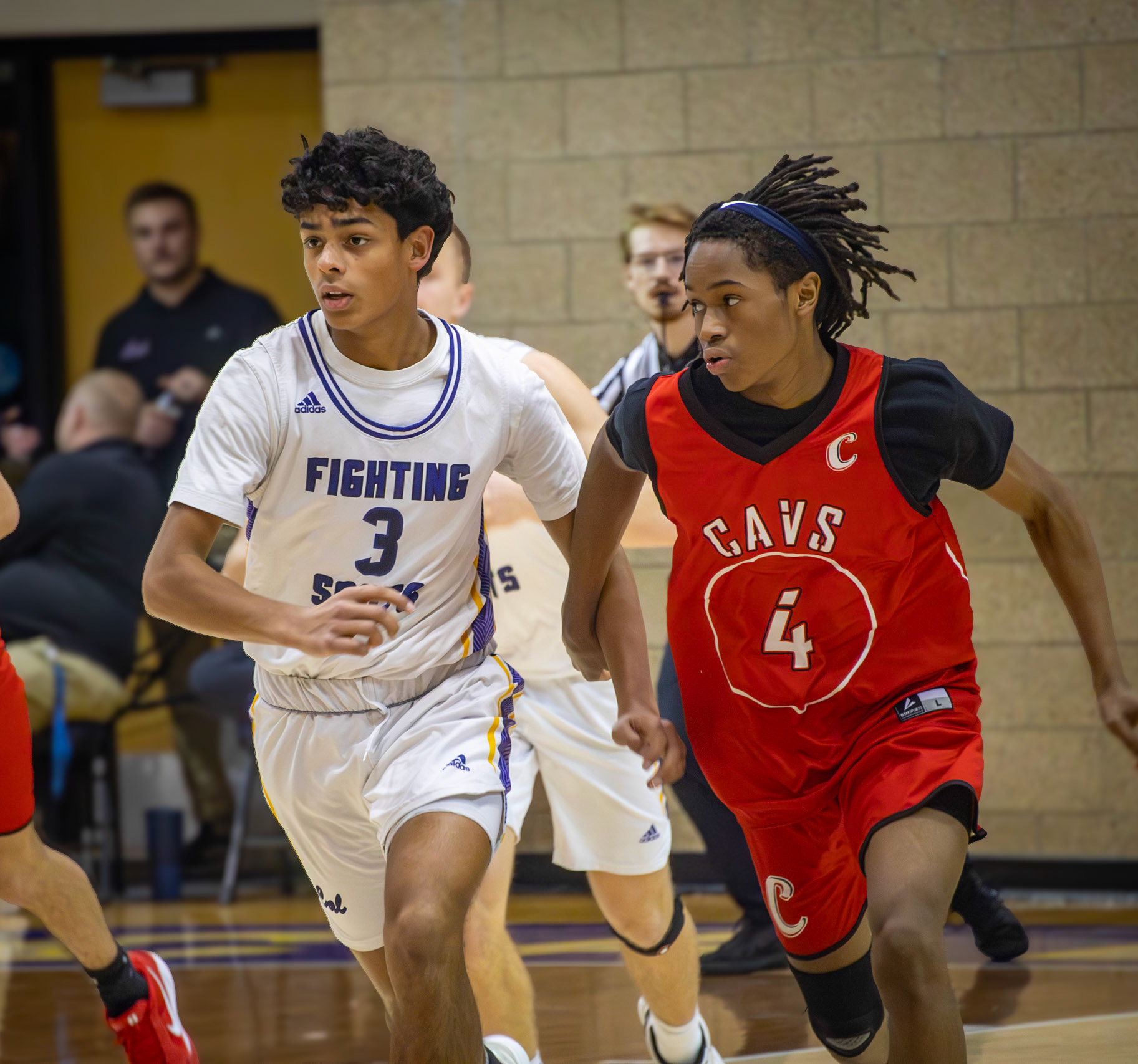 Jaden Emerson head to head with a Carrollton Cav as they race down the court for the ball. (Photo by Khloe Lowande)