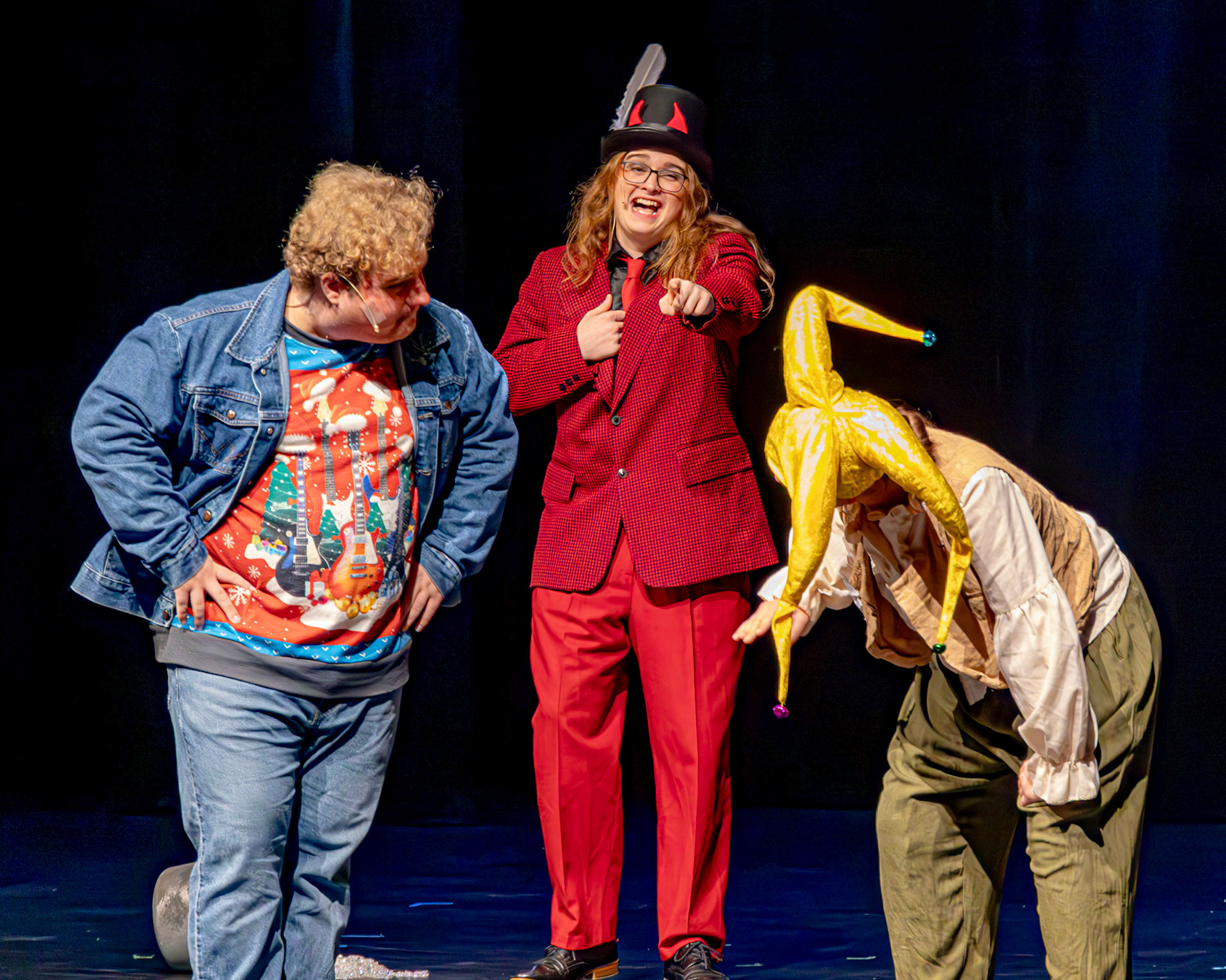 DEVILISH LAUGH  Rumpelstilskin, played by Stella Barnwell, stomps his feet so hard he gets stuck in the floor and when he tries to pull them out, he dies, while the Narrator, played by Alister Brew, looks on. The devil, played by Owen Williams, just laughs. (Photo by Ollie Fox)