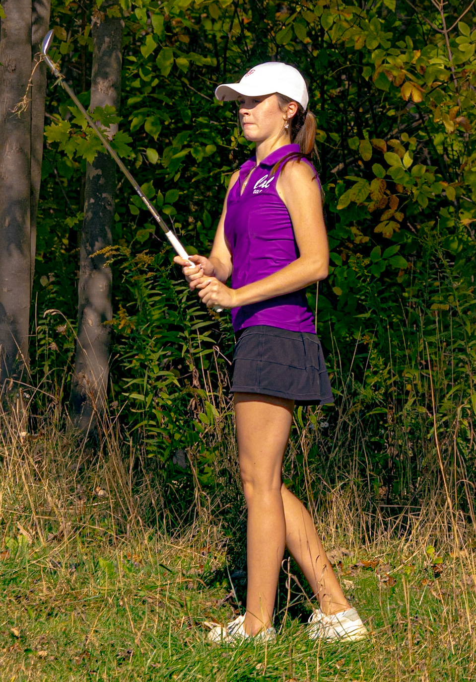 Senior Codie O'Krangley takes a look at her difficult shot out of the rough. (Photo by Derrick Sturman)