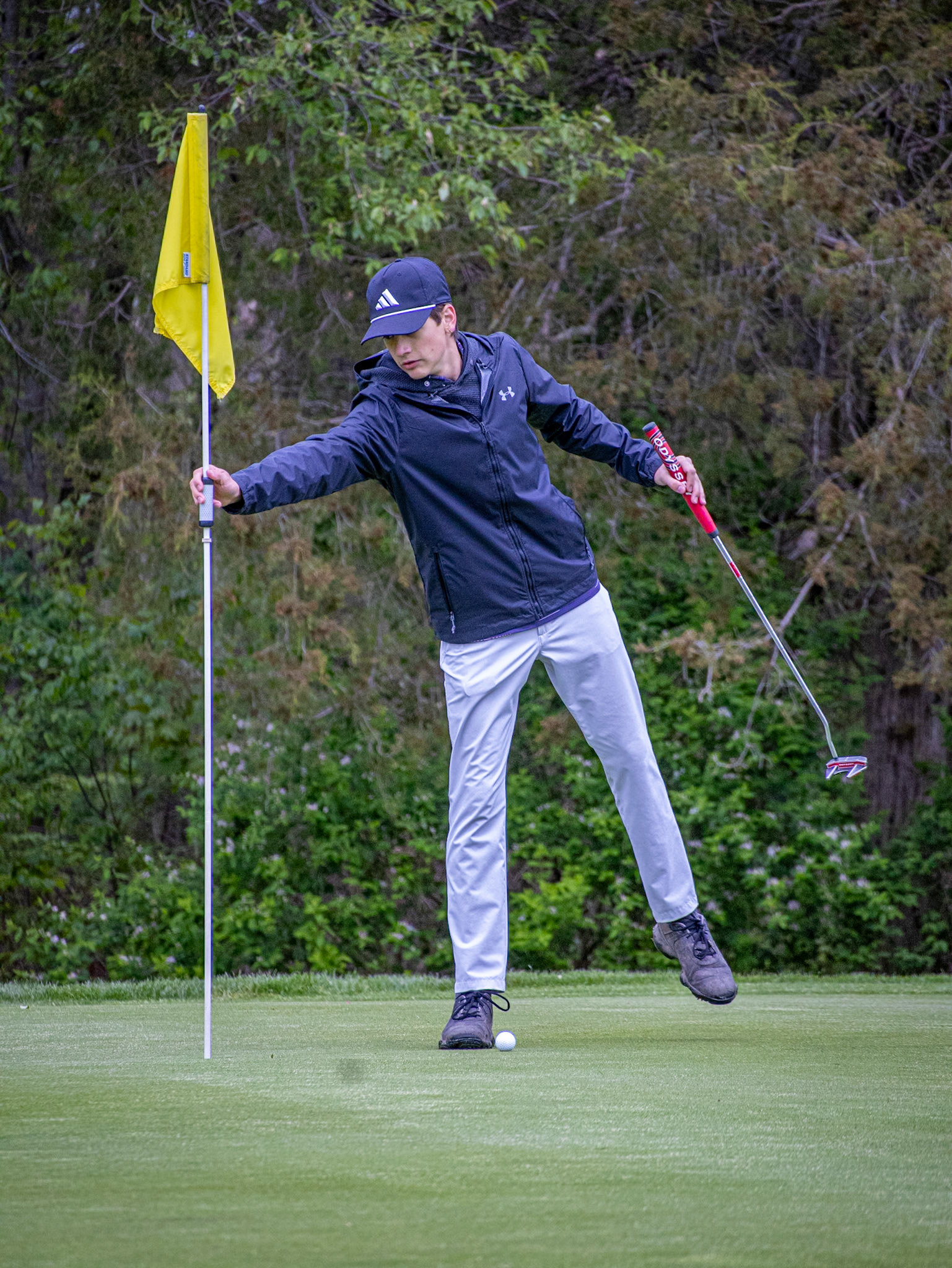 Nolan Van'tHof grabs the flag before his putt. (Photo by Aaron Pyper)