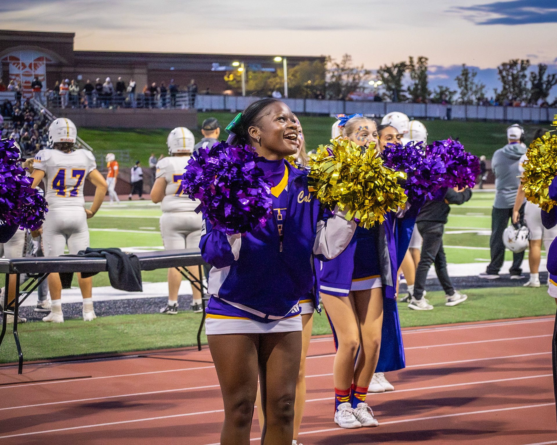 Junior Ahnya Pittman shares a bright smile with the crowd while cheering on the team at an away game against Rockford. (Photo by Avarey Lippert)