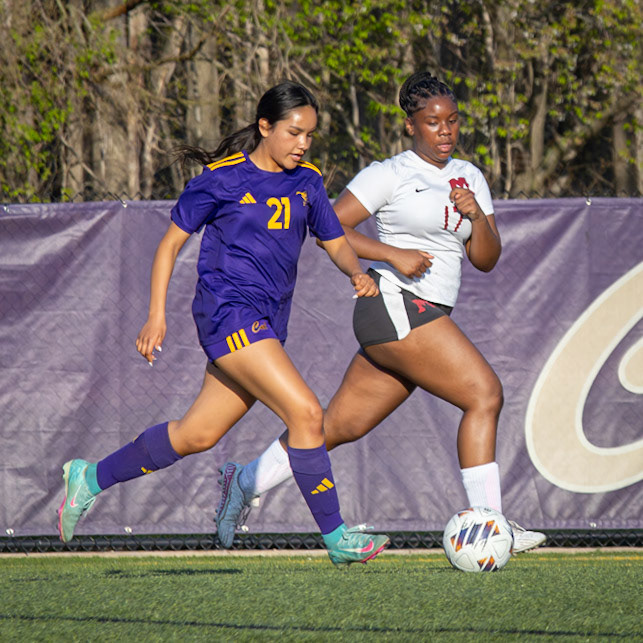 Explosive, Jazmyn sprints down the field with her defender chasing, both locked in on the ball. (Photo by Aibree Akers)