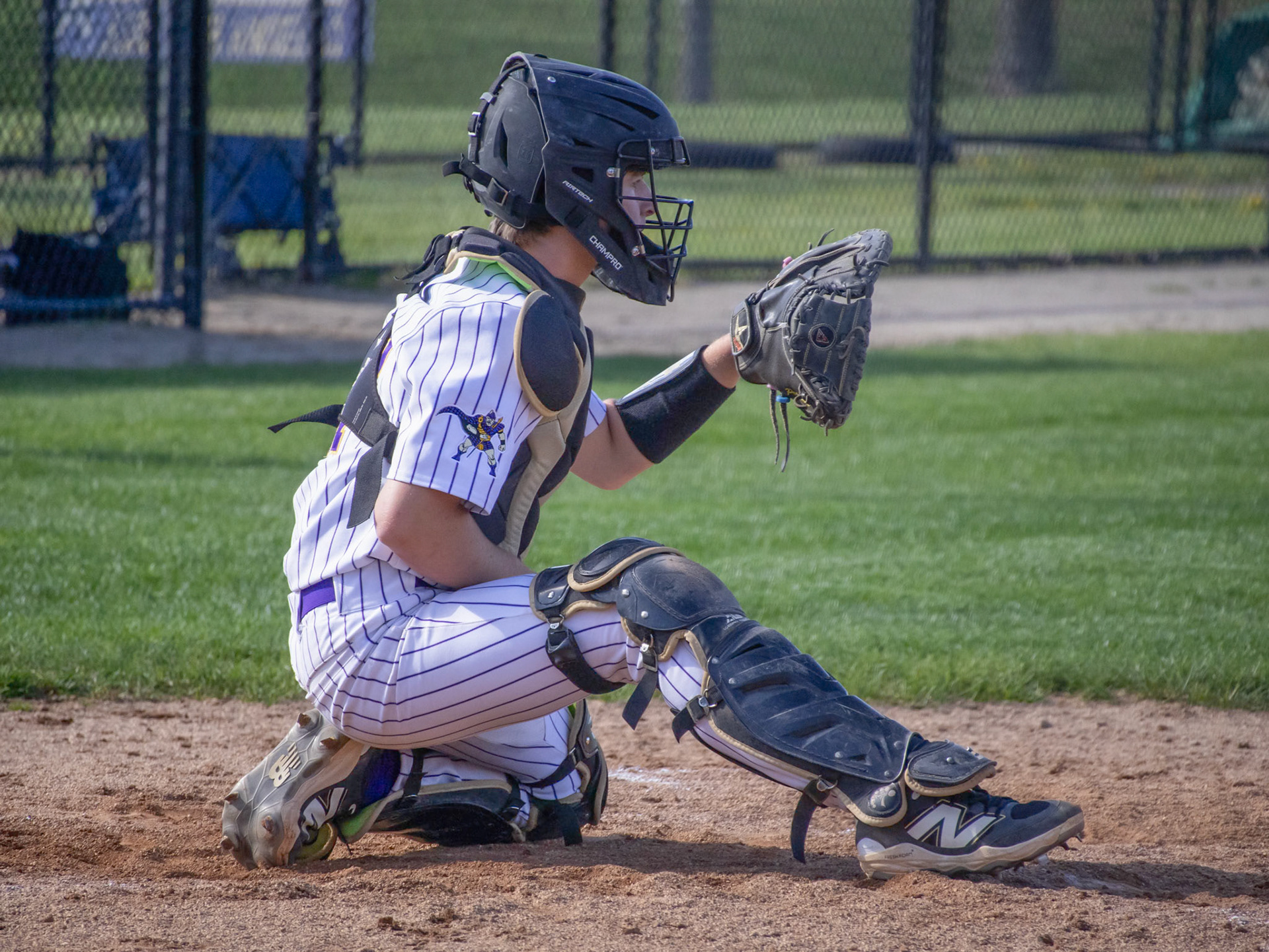 Knelt down, Clayton Paggeot signals the next pitch to pitcher Bryce Johnson. (Photo by Ella-Grace Wickens)