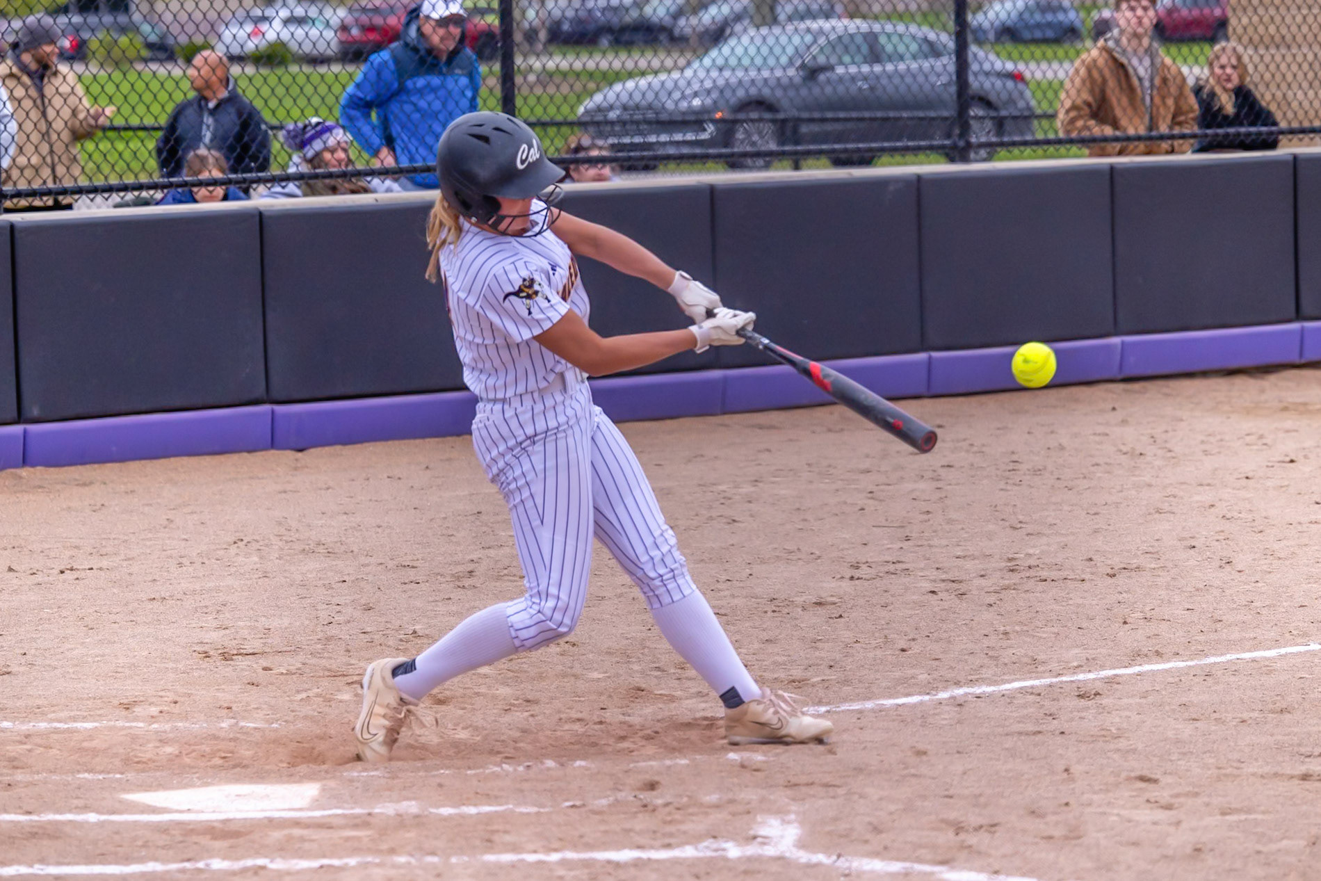 Addison Veldt connects with the pitch and drives the ball into play for the Scots. (Photo by Landry Mueller)