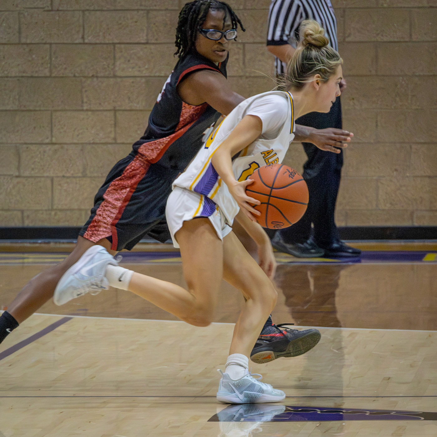 Maya Terryn drives toward the basket under tight defense during the Muskegon matchup. (Photo by Taya Penoes)