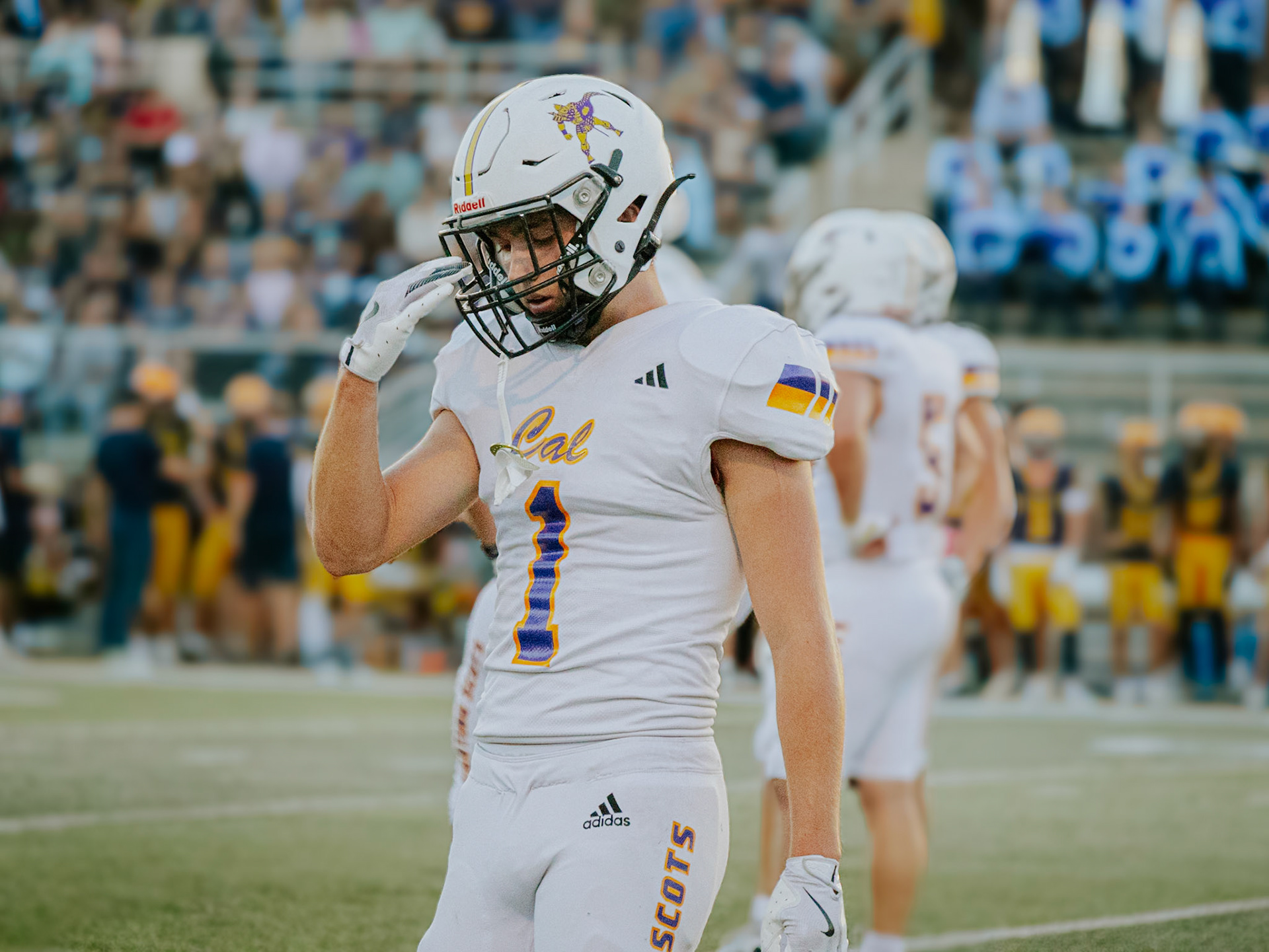 Aaron Collins stays composed and ready, tightening his helmet before the next snap against Hudsonville. (Photo by Lillian Jackson)