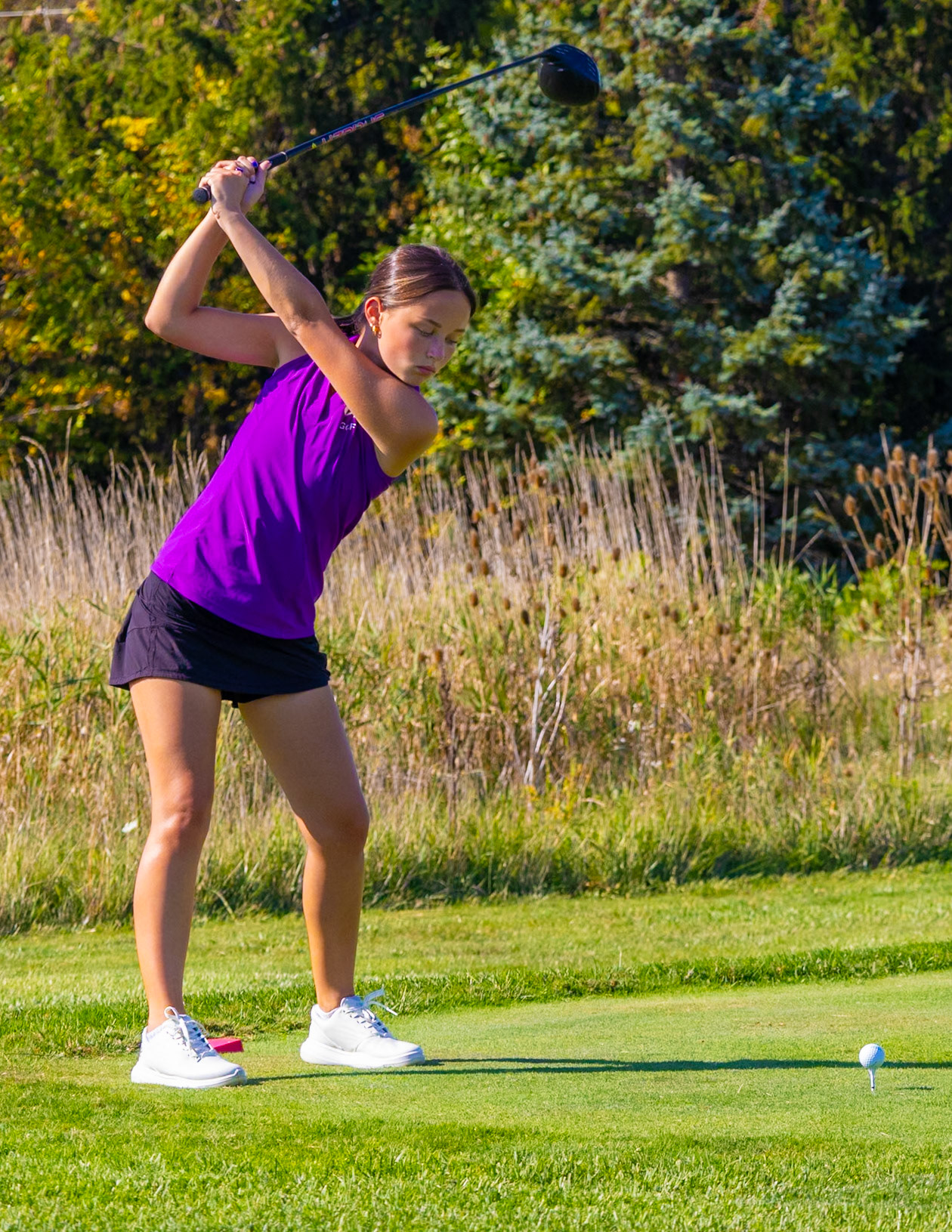 Senior Katie HonHart takes a hard swing for a perfect drive. (Photo by Derrick Sturman)
