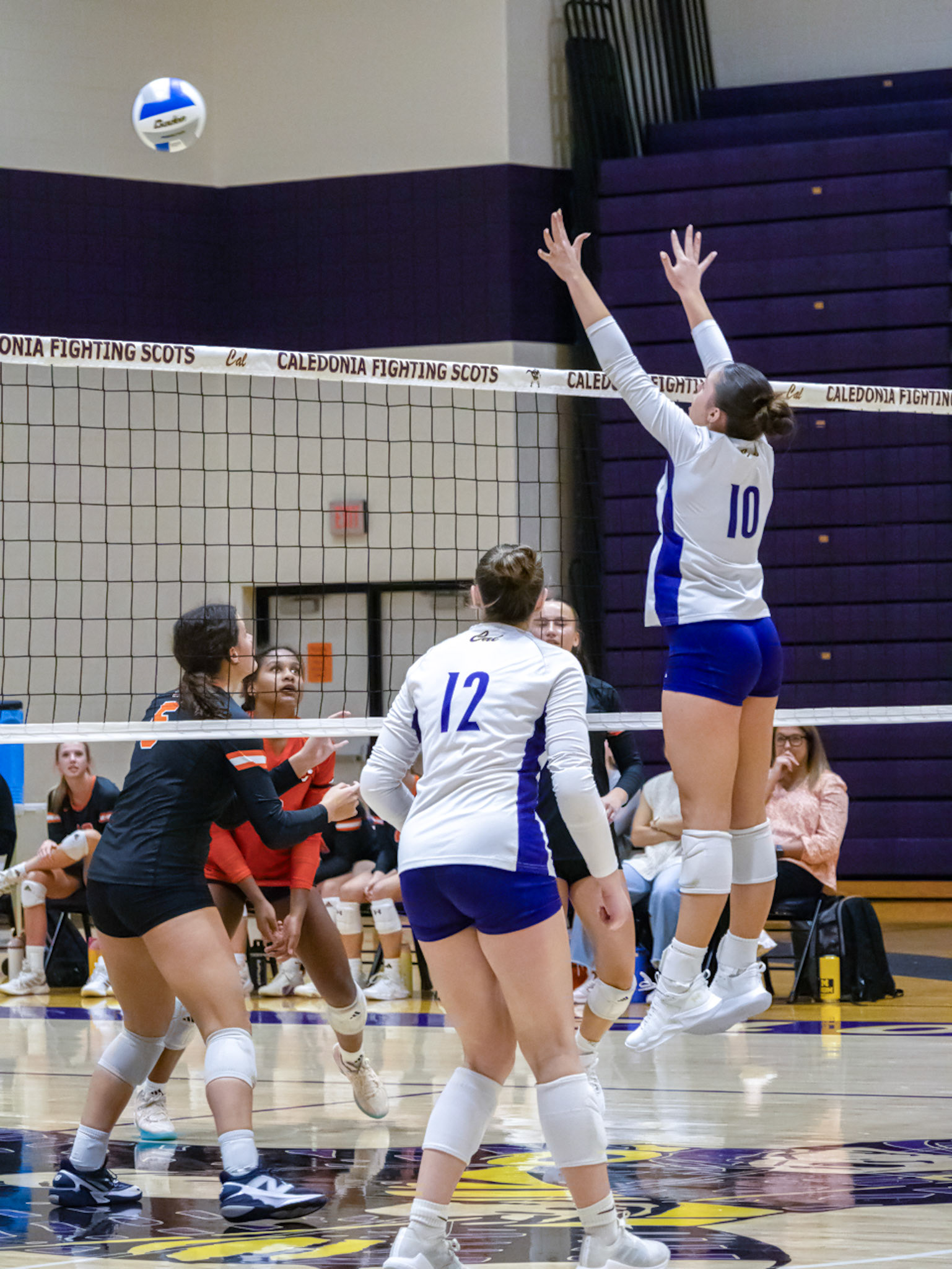 VERTICAL VAULT  Lydia Bell jumps to block the Byron Center Bulldogs’ shot. (Photo by Tana Coates)