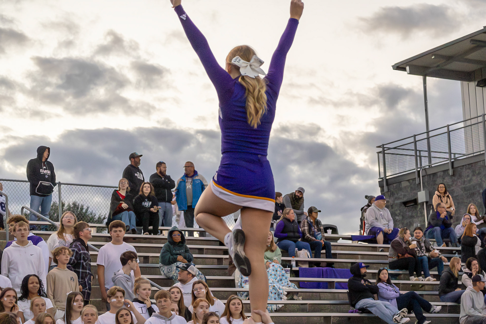 Senior Alyssa Jenigan faces the students while doing a stunt. She has always loved cheer, especially cheering at football games. (Photo by Avarey Lippert)