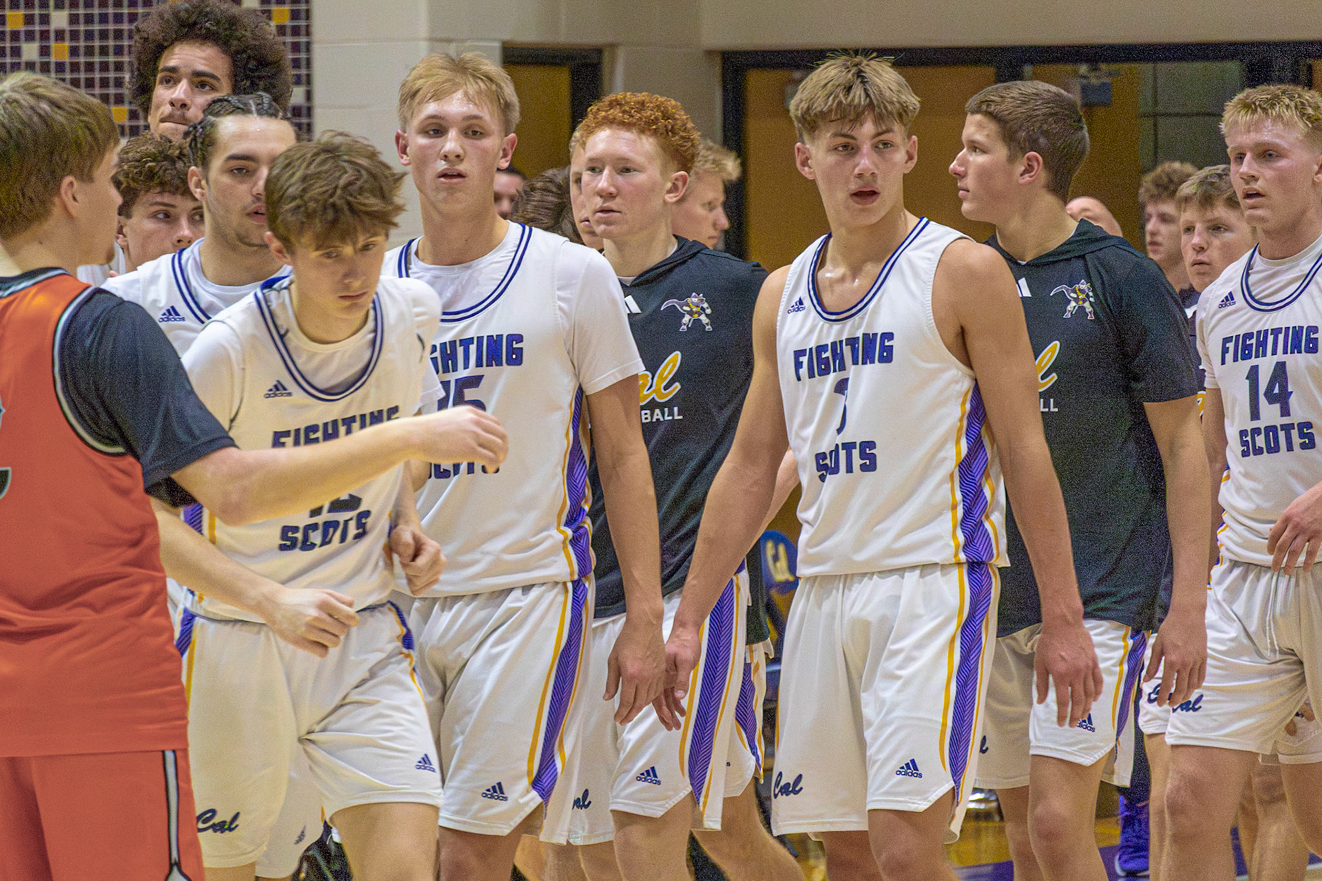 After a timeout, the varsity boys basketball team regroups and heads back onto the court to execute their game plan. (Photo by Emma Garza)