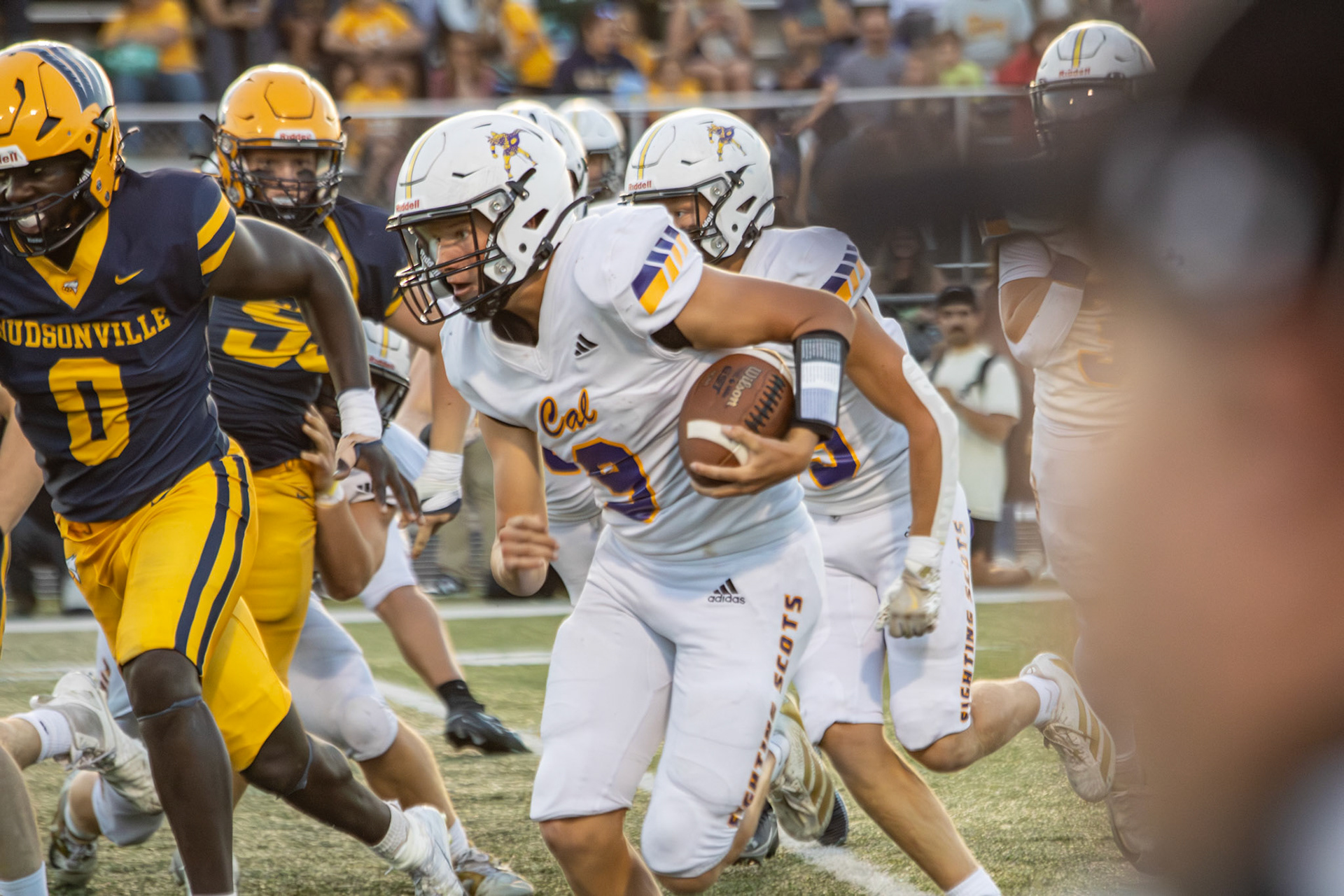 Conlan Schultz sprints down the field against Hudsonville, fighting for a touchdown run. (Photo by Taya Penoes)