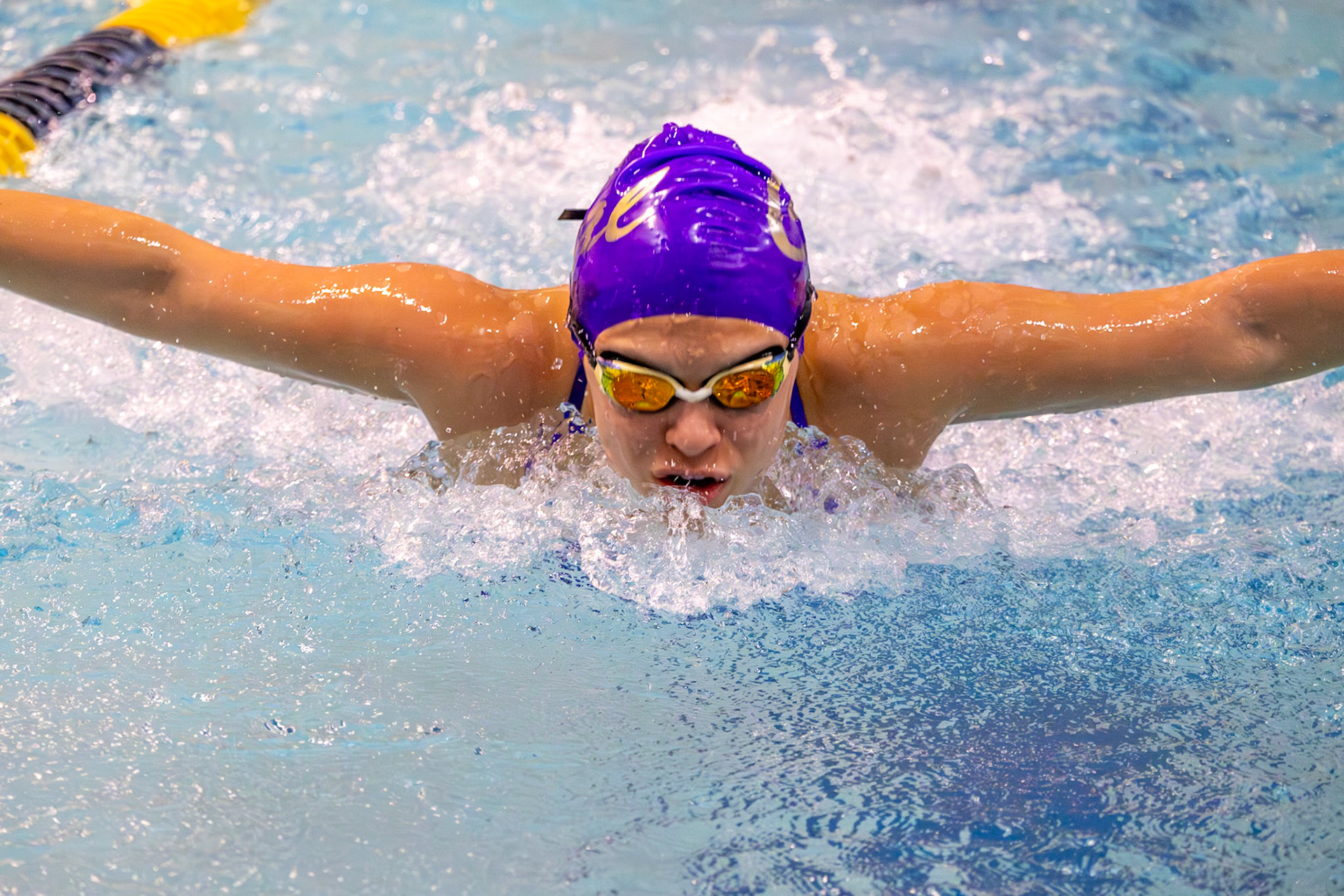 Lena Gesing races the 100-yard butterfly with determination, holding her pace through each demanding stroke. (Photo by Hailey Thayer)