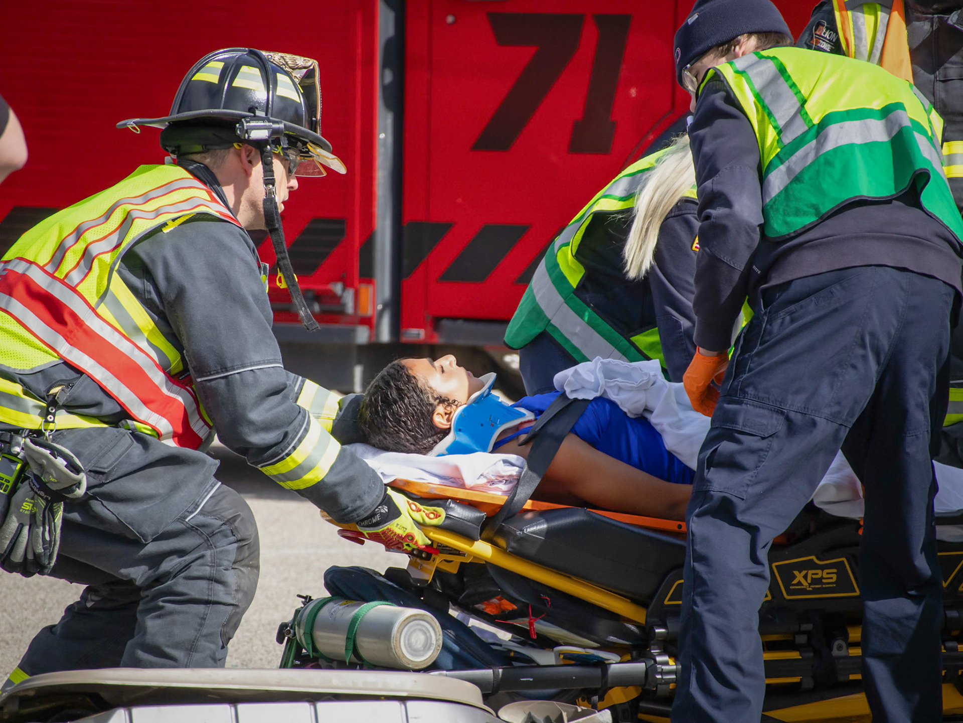 After being placed on a stretcher and wheeled into an ambulance, Tiona Sakala plays the role of a crash victim during the staged accident reenactment. (Photo by Ella-Grace Wickens)