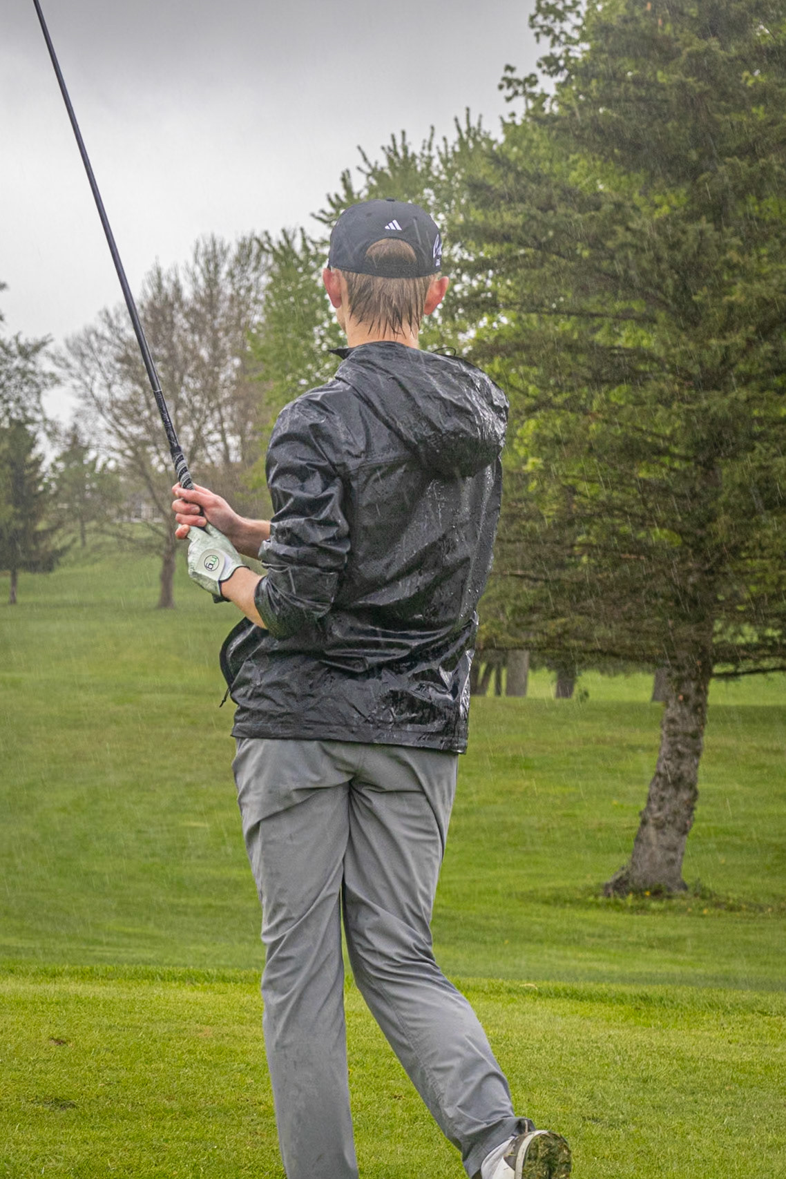 Anderson Collins watches his ball roll across the green. In the rain. (Photo by Emma Garza)